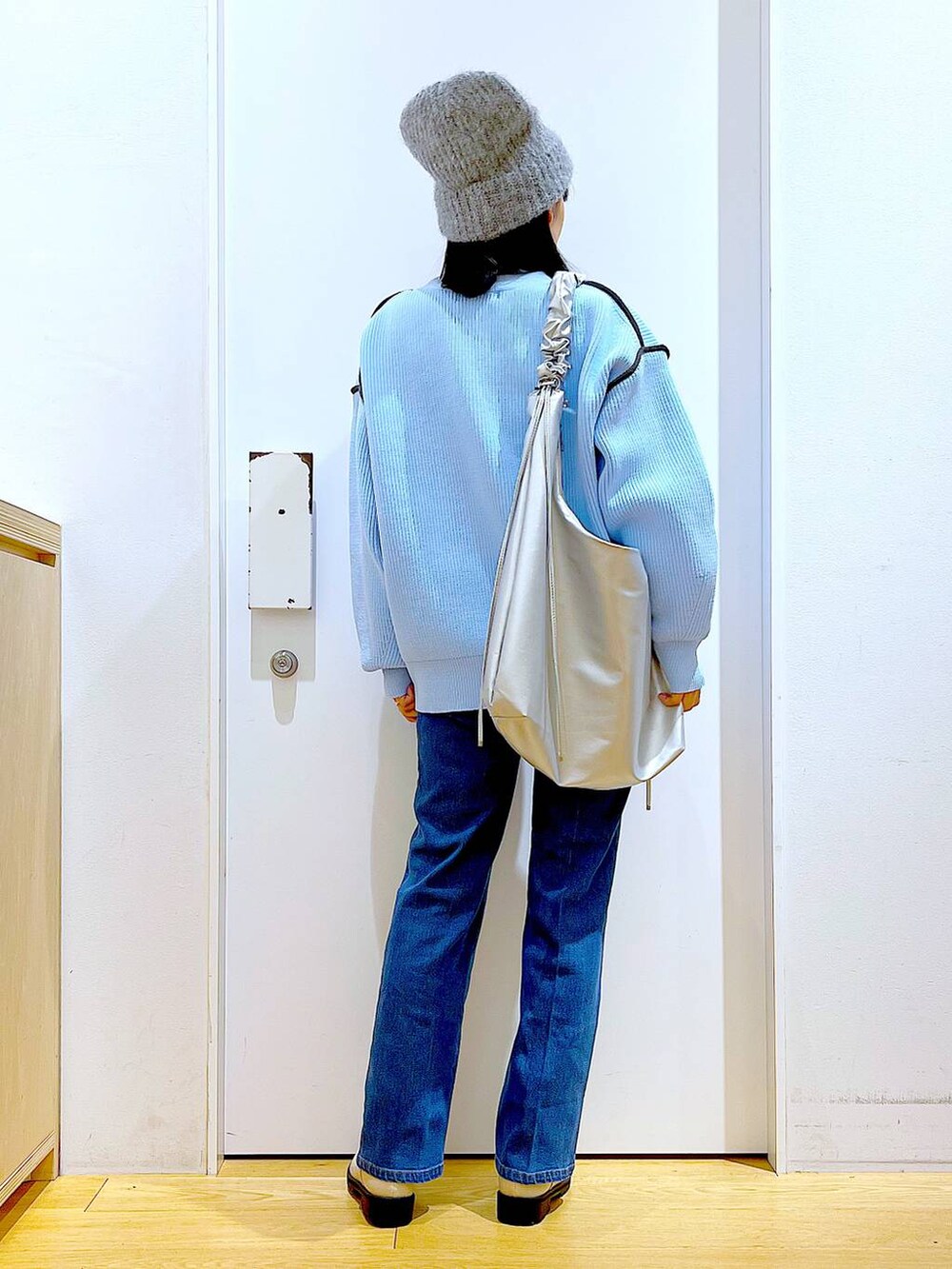 ブルー系のデニムパンツ、ベージュ系のブーツ、ベージュ系のニット/セーターを着用したレディースの冬コーディネートの5枚目の写真