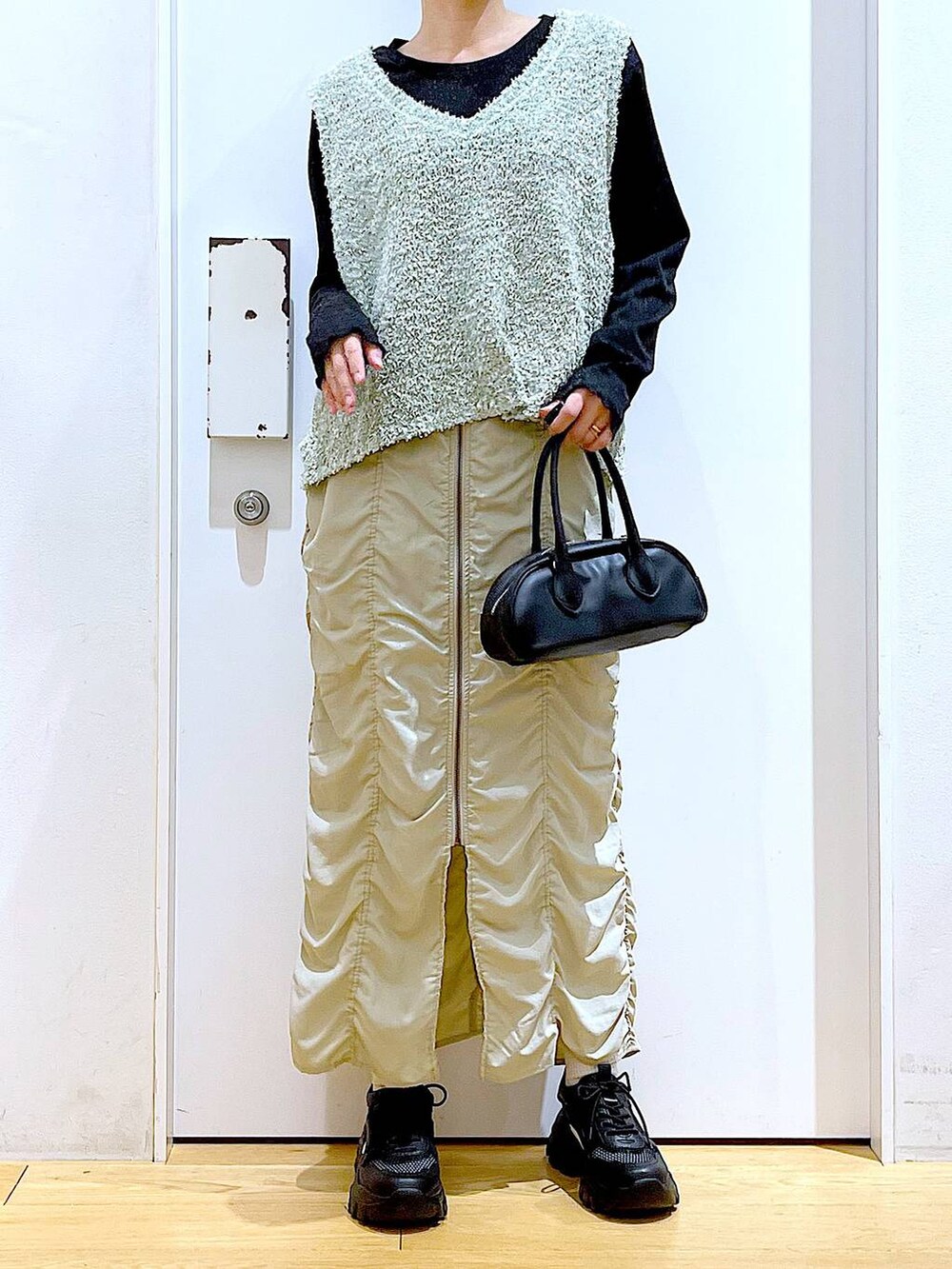 ベージュ系のスカート、ブラック系のボストンバッグ、ブラック系のTシャツ/カットソーを着用したレディースの春コーディネートの6枚目の写真