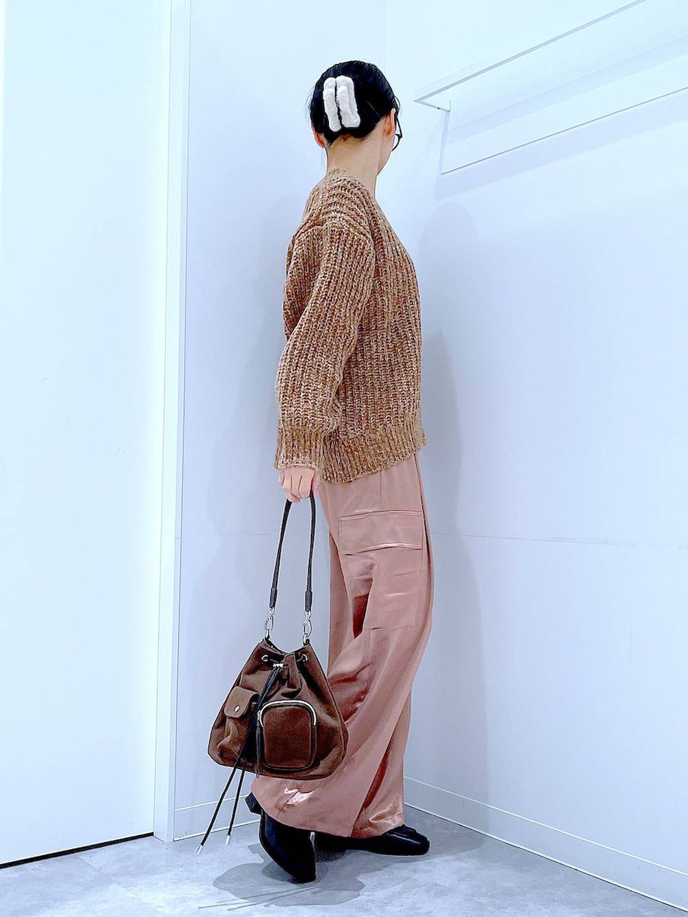 ブラウン系のニット/セーター、ブラウン系のショルダーバッグ、ブラック系のブーツを着用したレディースの冬コーディネートの4枚目の写真