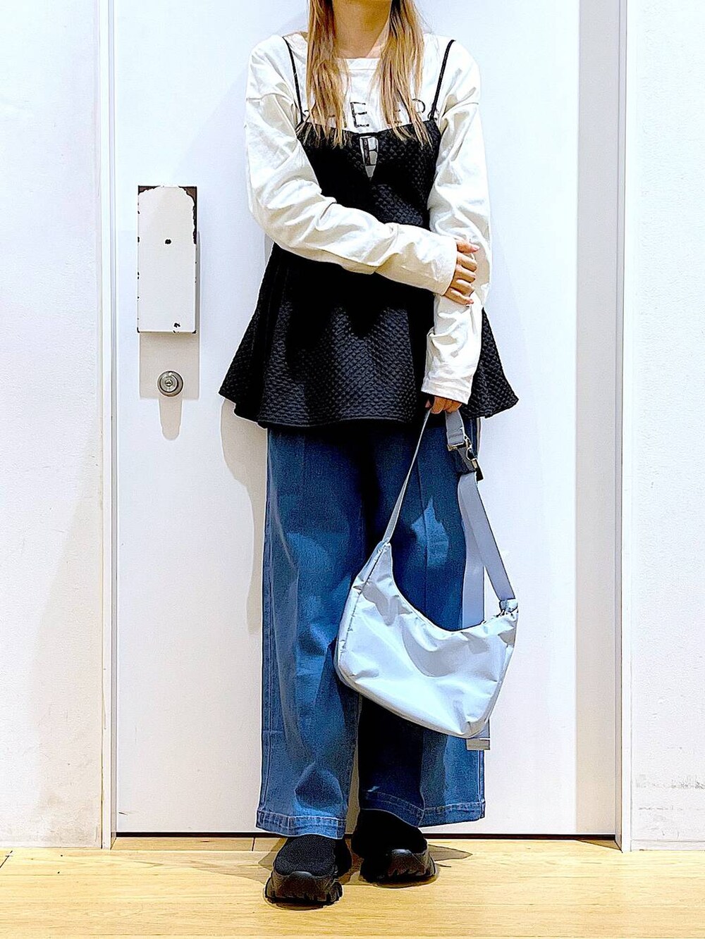 ブルー系のデニムパンツ、ホワイト系のTシャツ/カットソー、ブルー系のショルダーバッグを着用したレディースの春コーディネートの3枚目の写真