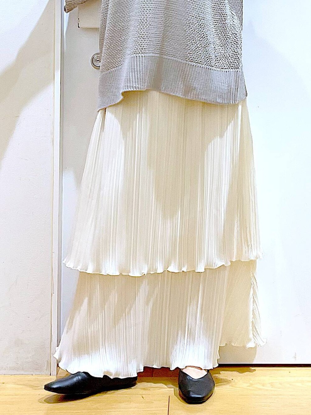 ブラック系のパンプス、ホワイト系のスカート、グレー系のニット/セーターを着用したレディースの春コーディネートの8枚目の写真