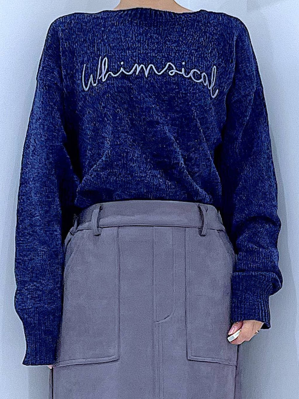 ブラック系のブーツ、ブルー系のニット/セーター、グレー系のスカートを着用したレディースの冬コーディネートの7枚目の写真