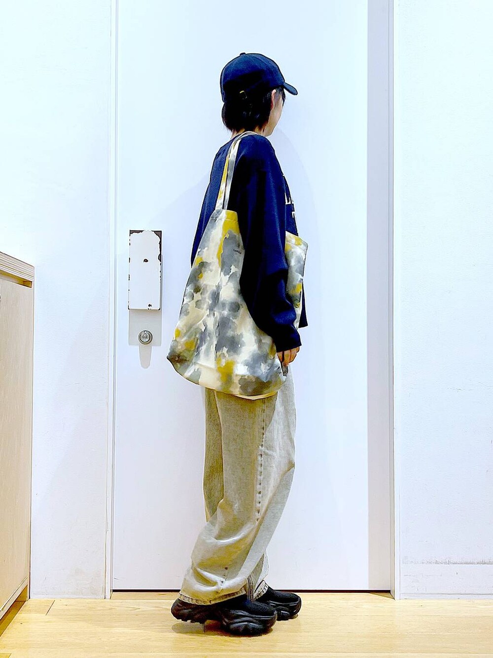 ブラック系のブーツ、ベージュ系のデニムパンツ、イエロー系のトートバッグを着用したレディースの冬コーディネートの4枚目の写真