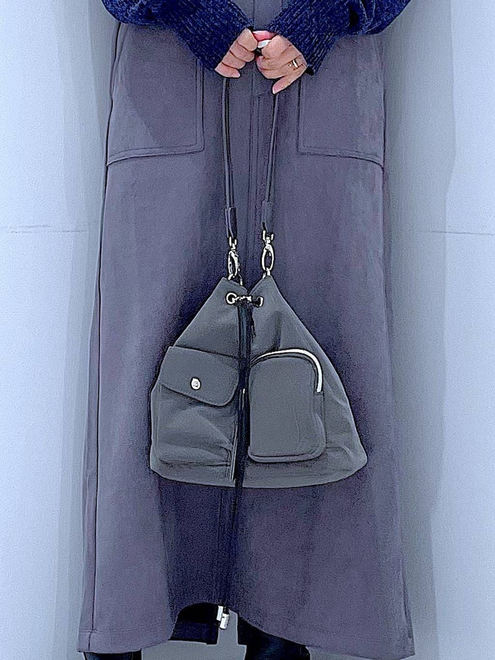 ブラック系のブーツ、ブルー系のニット/セーター、グレー系のスカートを着用したレディースの冬コーディネートの9枚目の写真