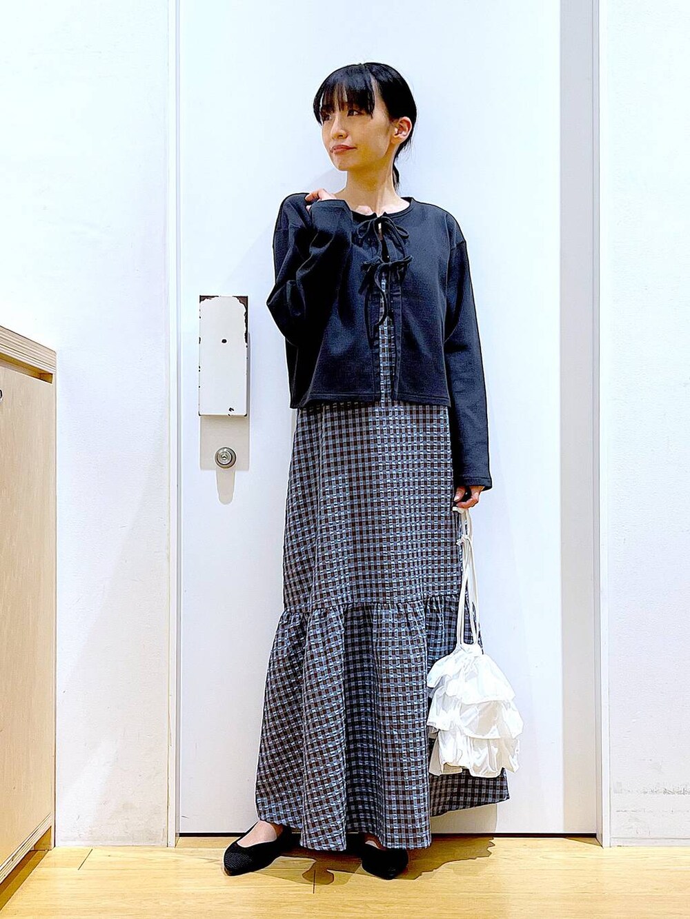 ホワイト系のショルダーバッグ、ブラック系のパンプス、ブルー系のワンピースを着用したレディースの春コーディネートの2枚目の写真