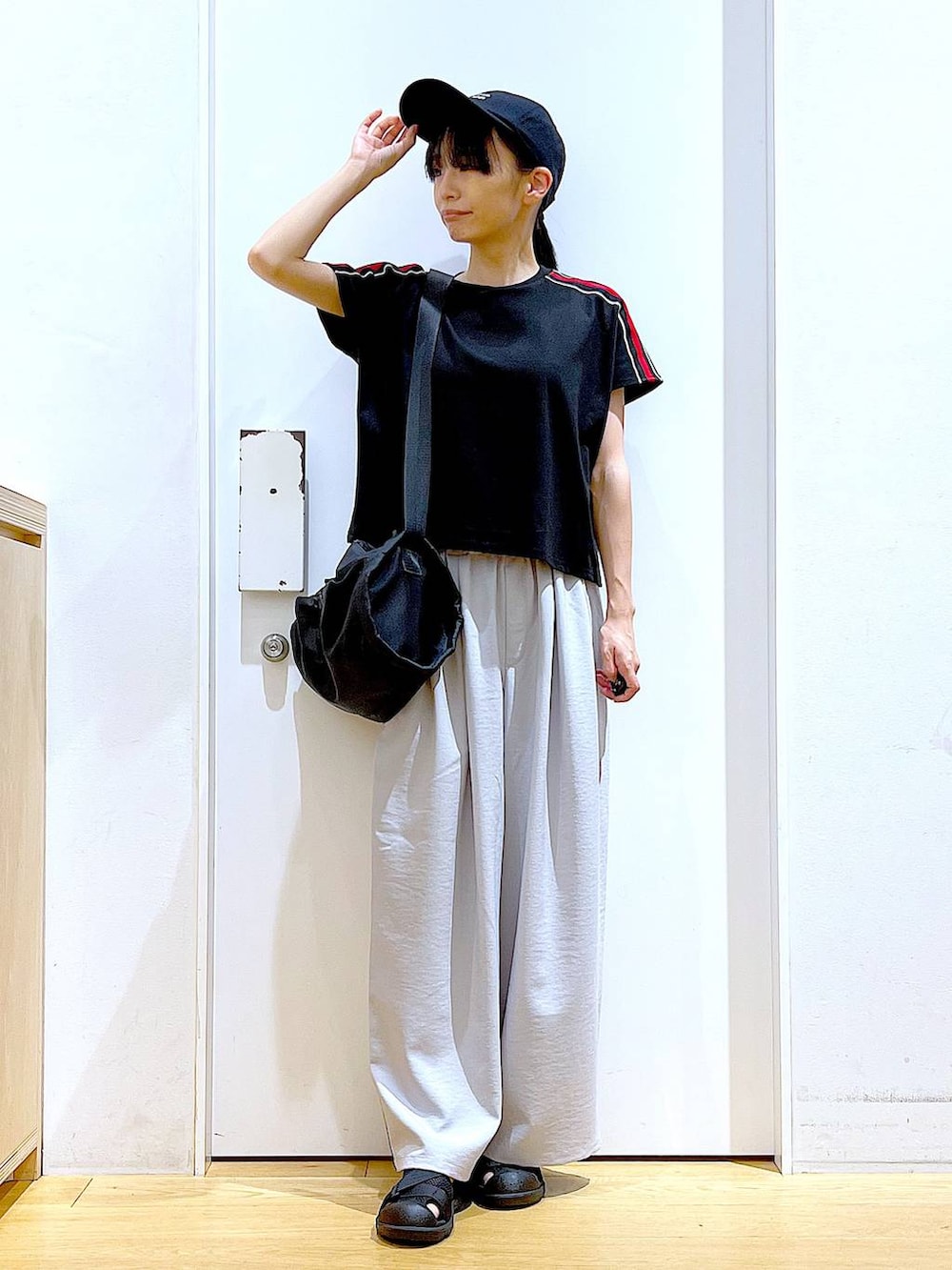 ブラック系のショルダーバッグ、ブラック系のスリッポン、ブラック系のTシャツ/カットソーを着用したレディースの春コーディネートの2枚目の写真