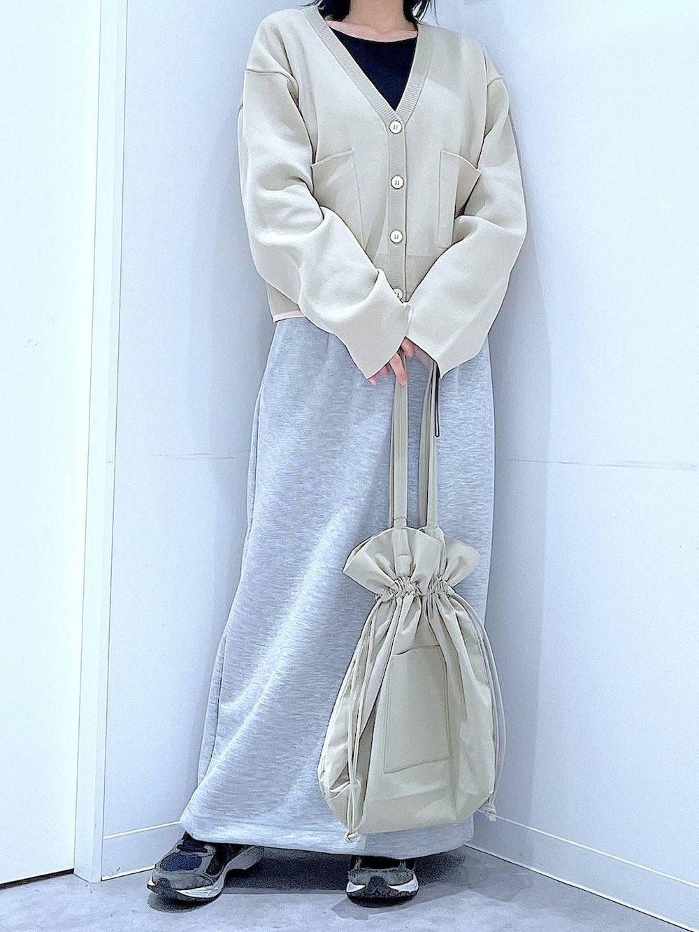 ブラック系のTシャツ/カットソー、ベージュ系のトートバッグ、グレー系のスカートを着用したレディースの冬コーディネートの6枚目の写真