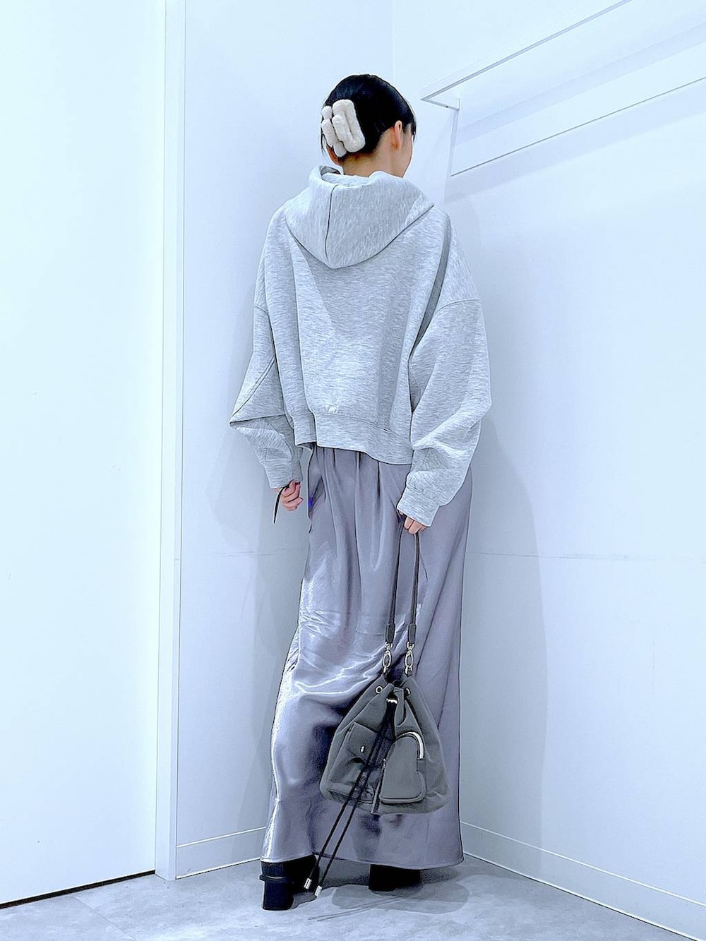 ブラック系のブーツ、グレー系のスカート、グレー系のパーカーを着用したレディースの春コーディネートの5枚目の写真