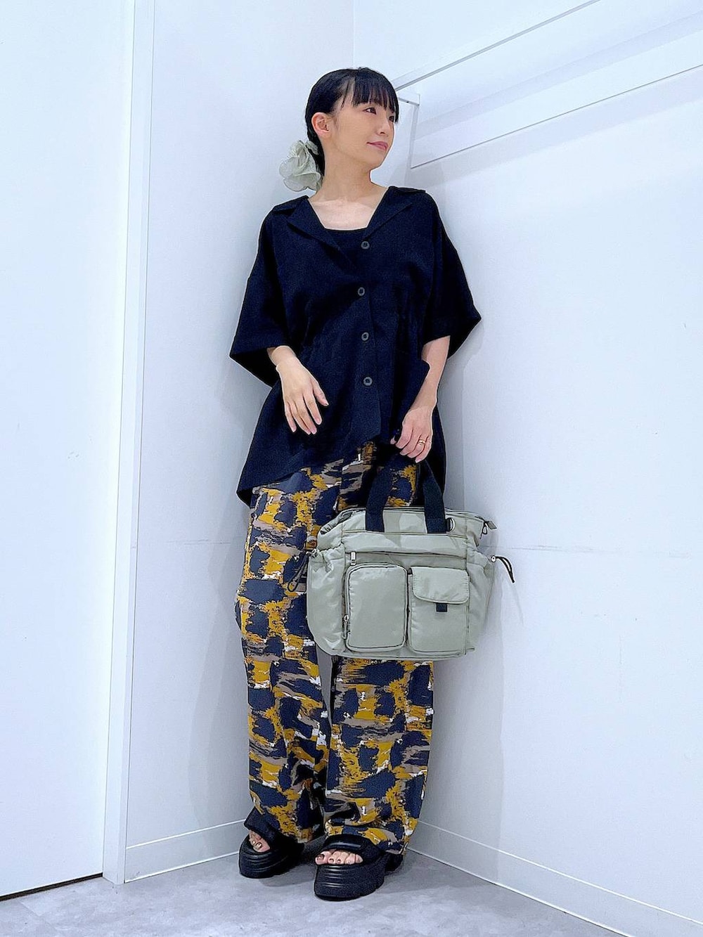 グレー系のその他パンツ、グリーン系のトートバッグ、ブラック系のサンダルを着用したレディースの夏コーディネートの2枚目の写真