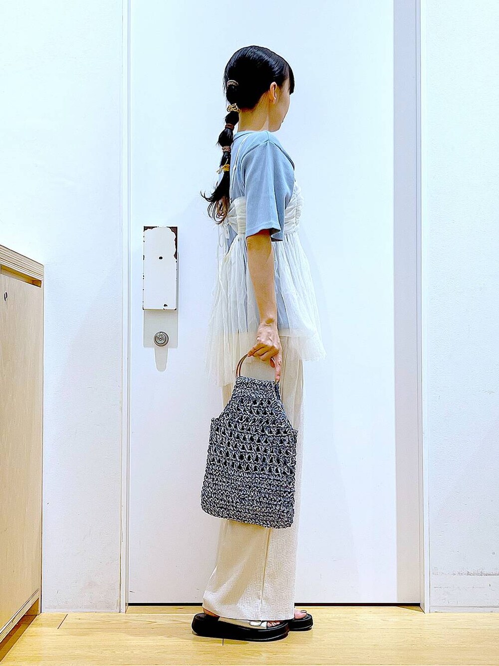 ホワイト系のキャミソール、シルバー系のサンダル、ブルー系のハンドバッグを着用したレディースの夏コーディネートの4枚目の写真