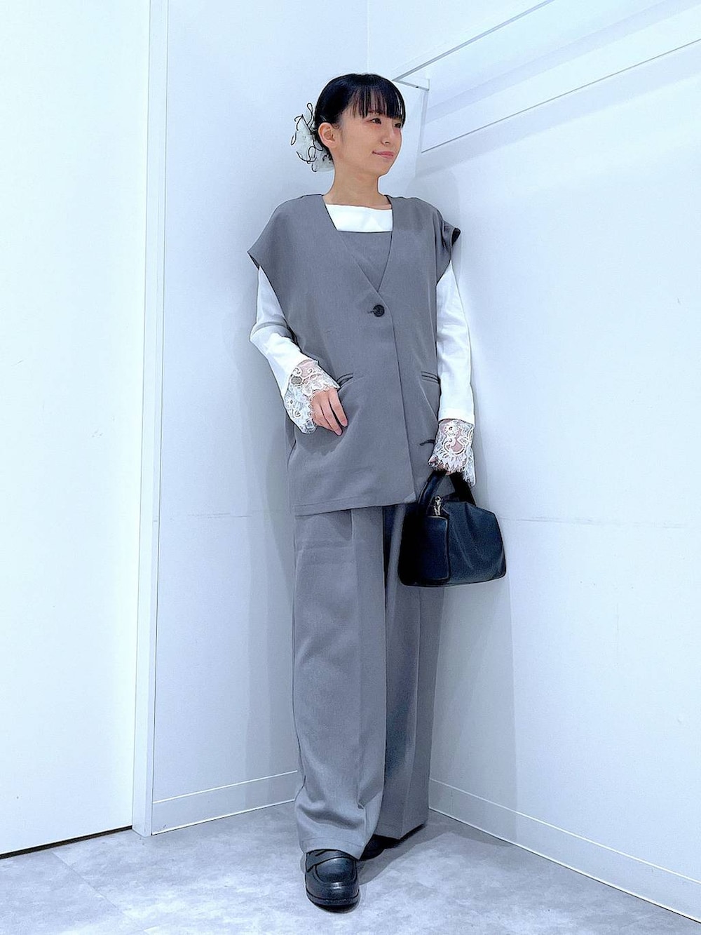 ブラック系のショルダーバッグ、グレー系のサロペット/オーバーオール、グレー系のベストを着用したレディースの冬コーディネートの2枚目の写真