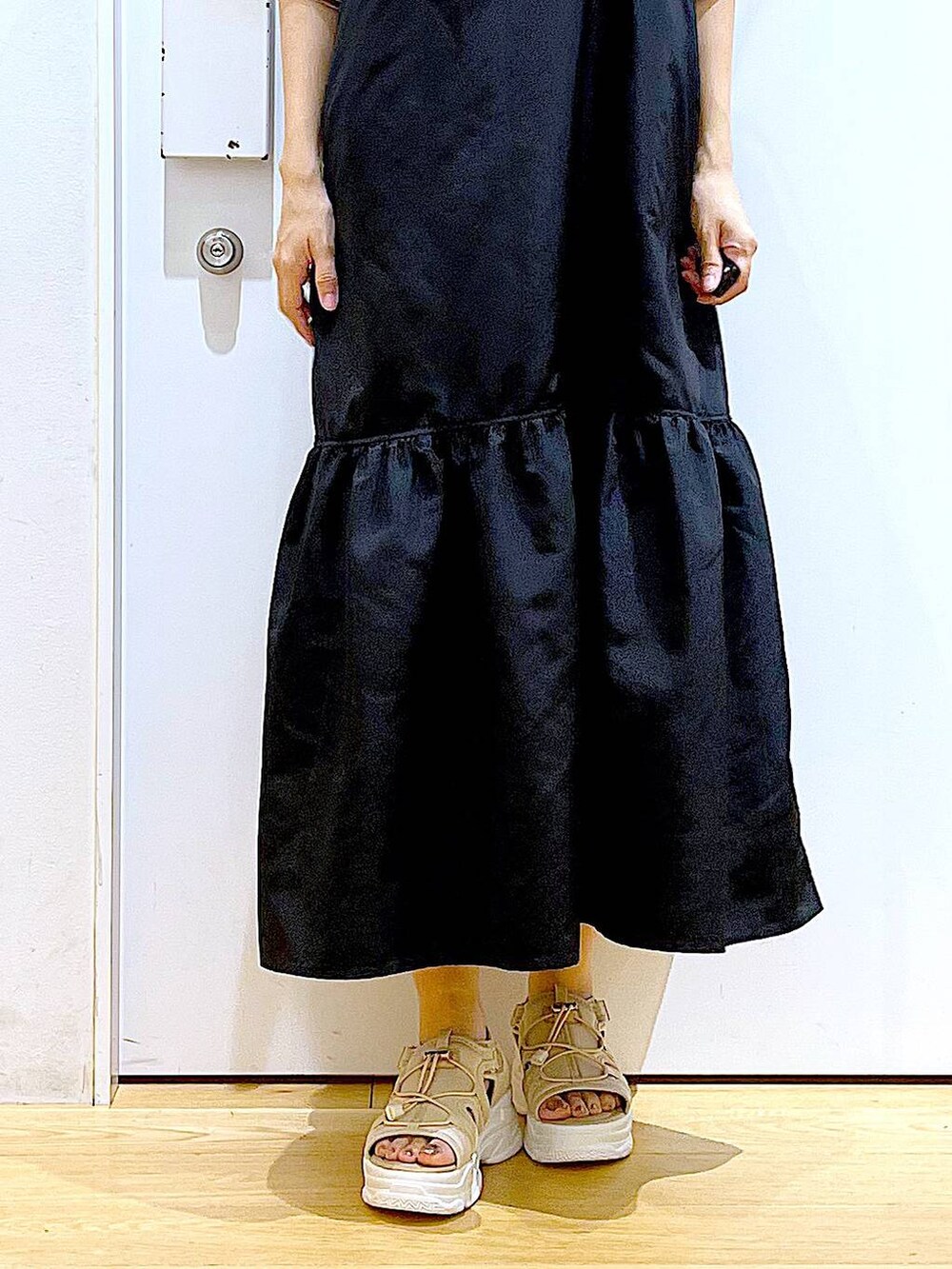 ホワイト系のショルダーバッグ、ブラック系のワンピース、ベージュ系のサンダルを着用したレディースの春コーディネートの8枚目の写真