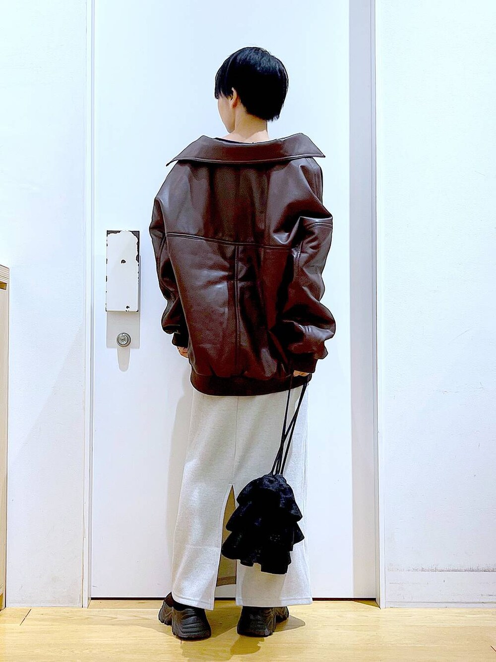 ブラウン系のブルゾン、ブラック系のブーツ、ブラック系のショルダーバッグを着用したレディースの冬コーディネートの5枚目の写真