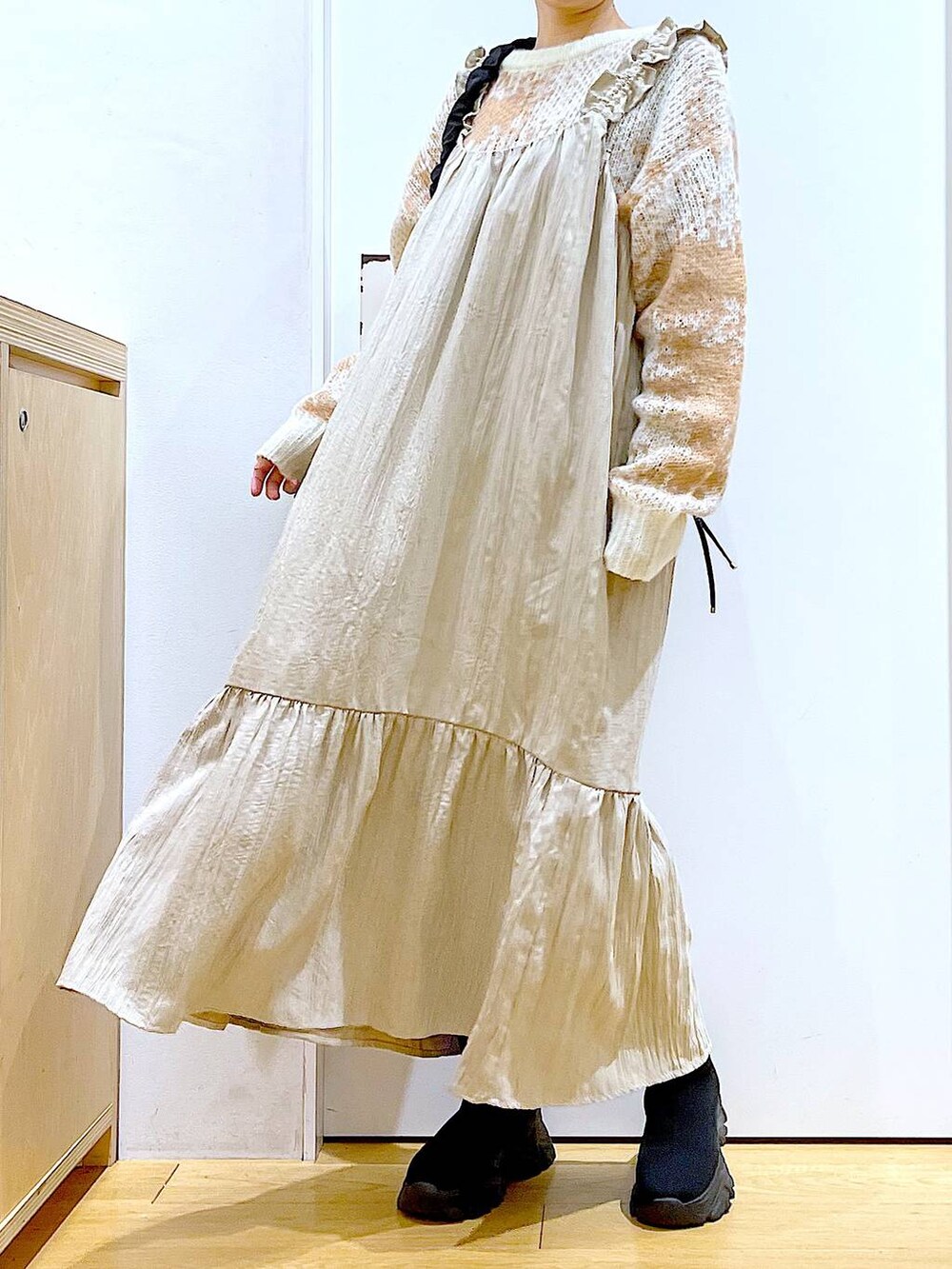 ブラック系のショルダーバッグ、ブラック系のブーツ、ベージュ系のワンピースを着用したレディースの冬コーディネートの6枚目の写真