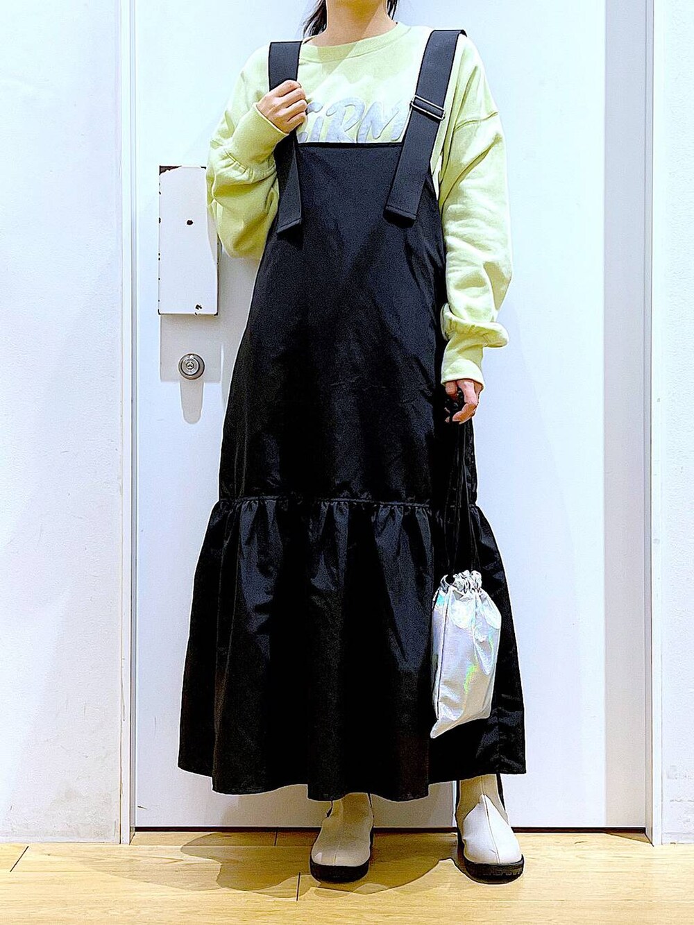 イエロー系のスウェット、ベージュ系のブーツ、その他のショルダーバッグを着用したレディースの冬コーディネートの6枚目の写真