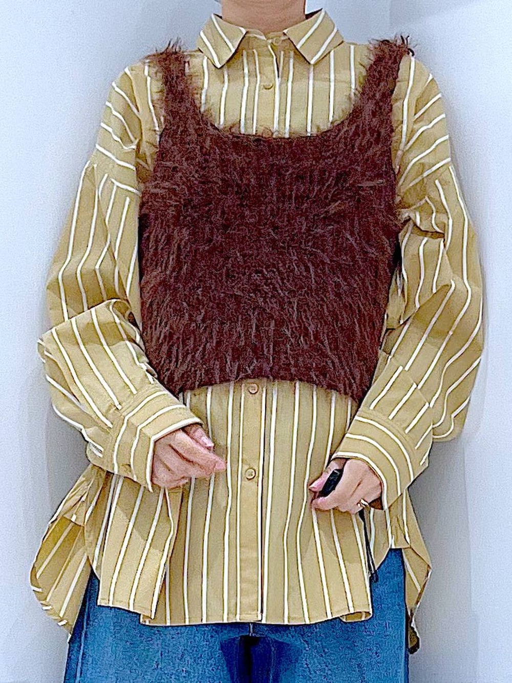 ブルー系のデニムパンツ、イエロー系のシャツ/ブラウス、ブラウン系のベストを着用したレディースの秋コーディネートの7枚目の写真