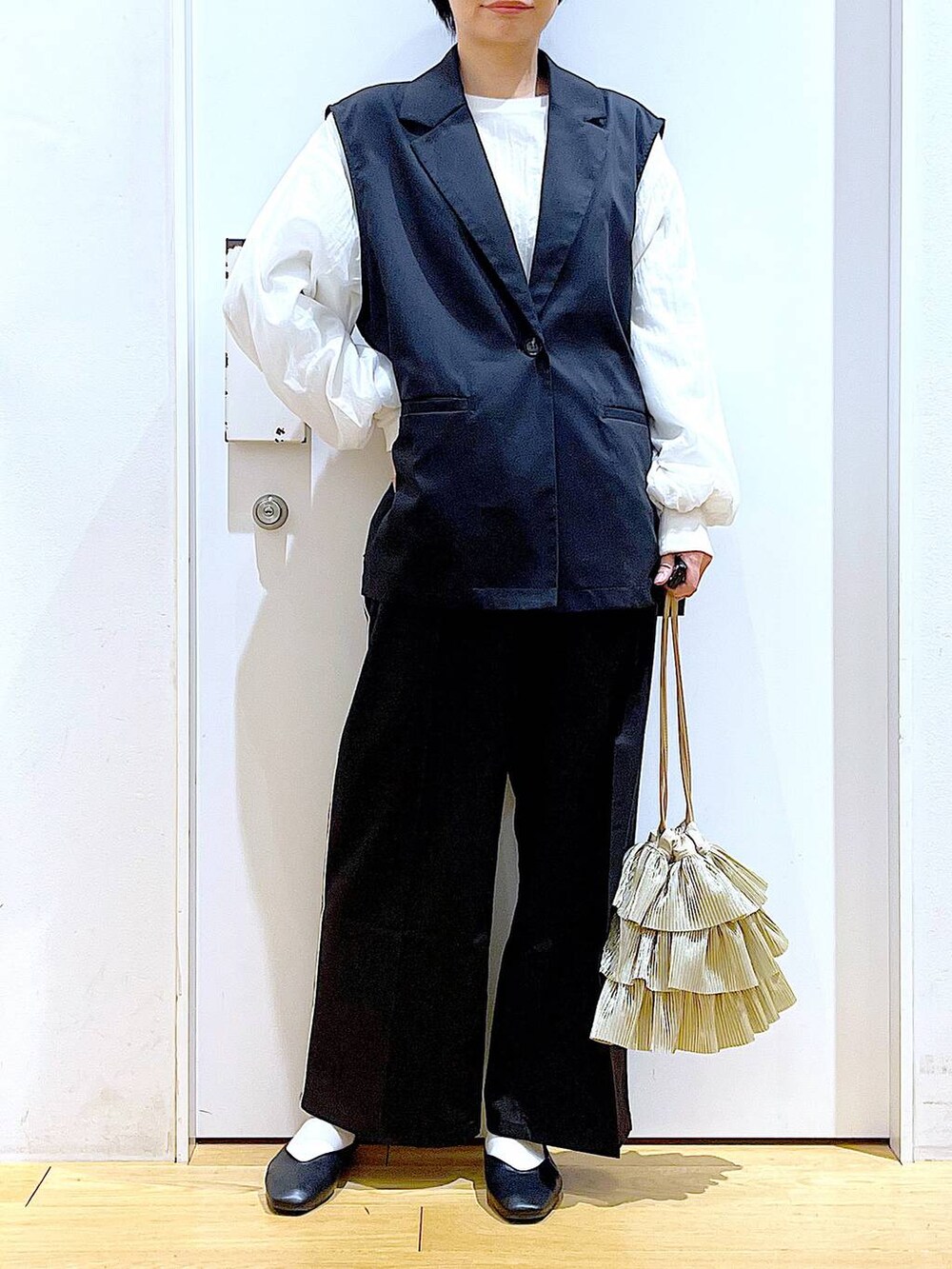 ブラック系のスラックス、ブラック系のパンプス、ホワイト系のスウェットを着用したレディースの春コーディネートの6枚目の写真