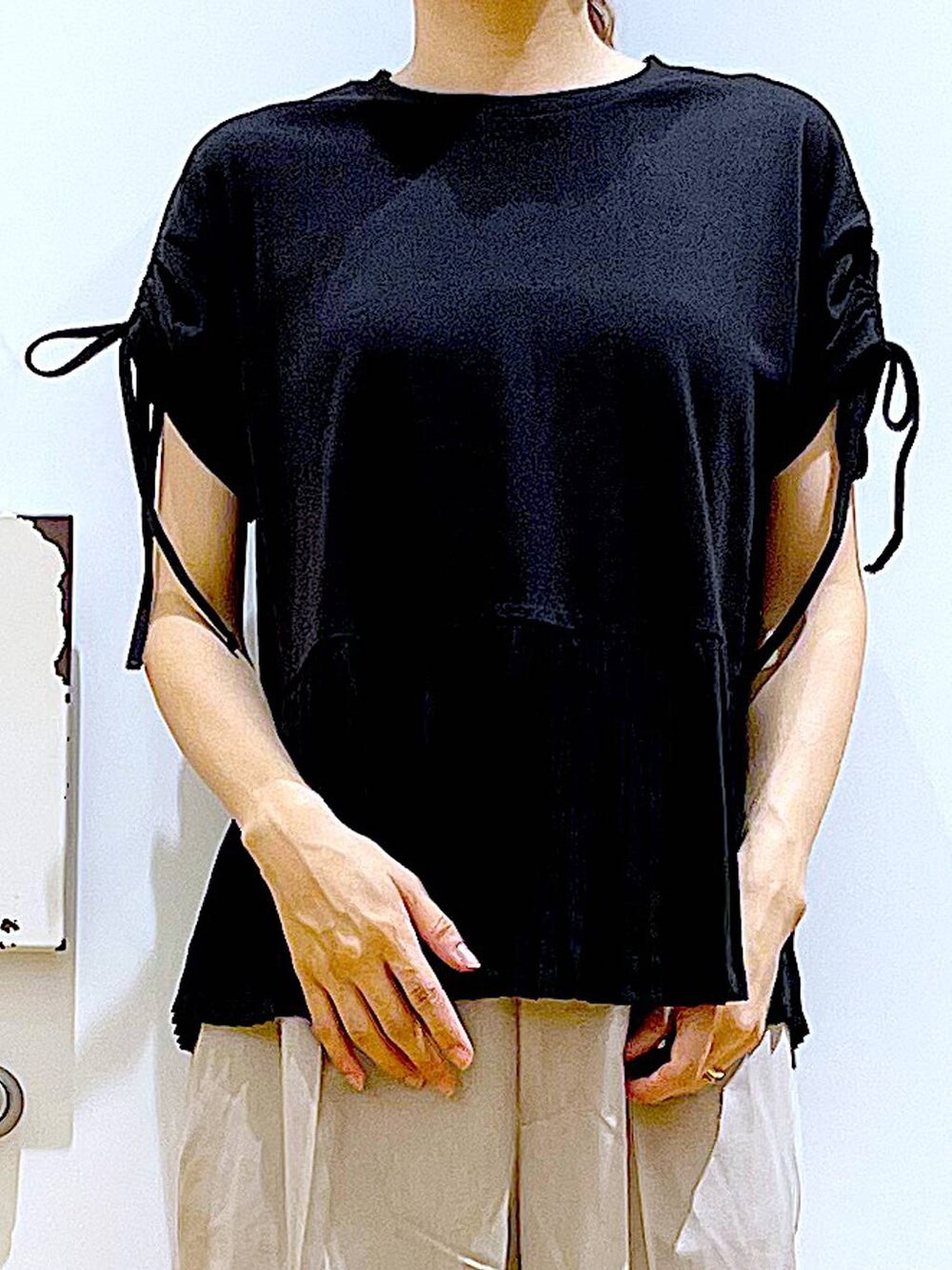 ホワイト系のサンダル、グリーン系のトートバッグ、ベージュ系のスラックスを着用したレディースの秋コーディネートの7枚目の写真