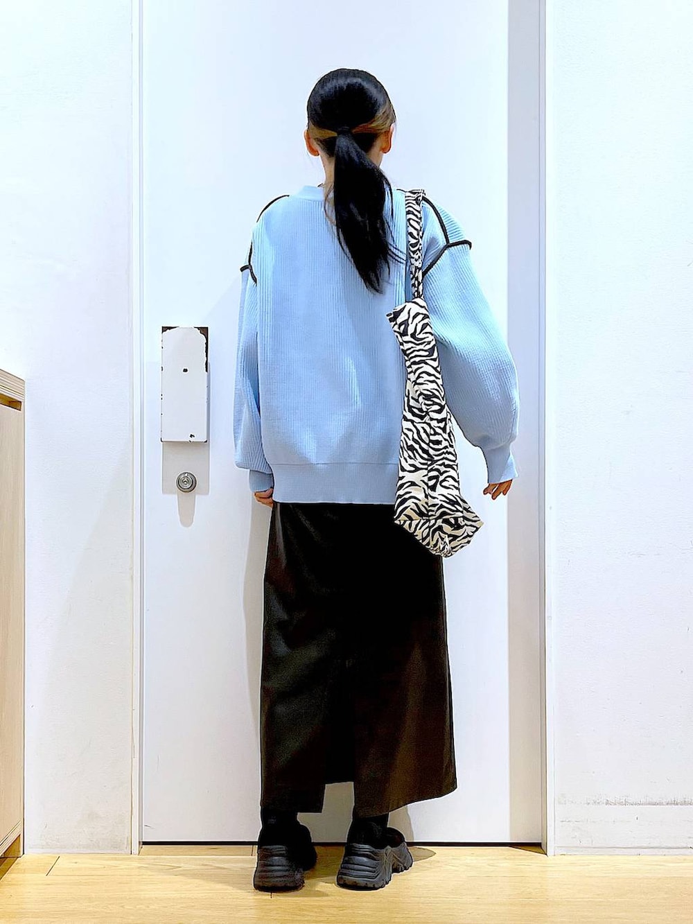 グレー系のTシャツ/カットソー、ブラック系のブーツ、その他のトートバッグを着用したレディースの春コーディネートの5枚目の写真