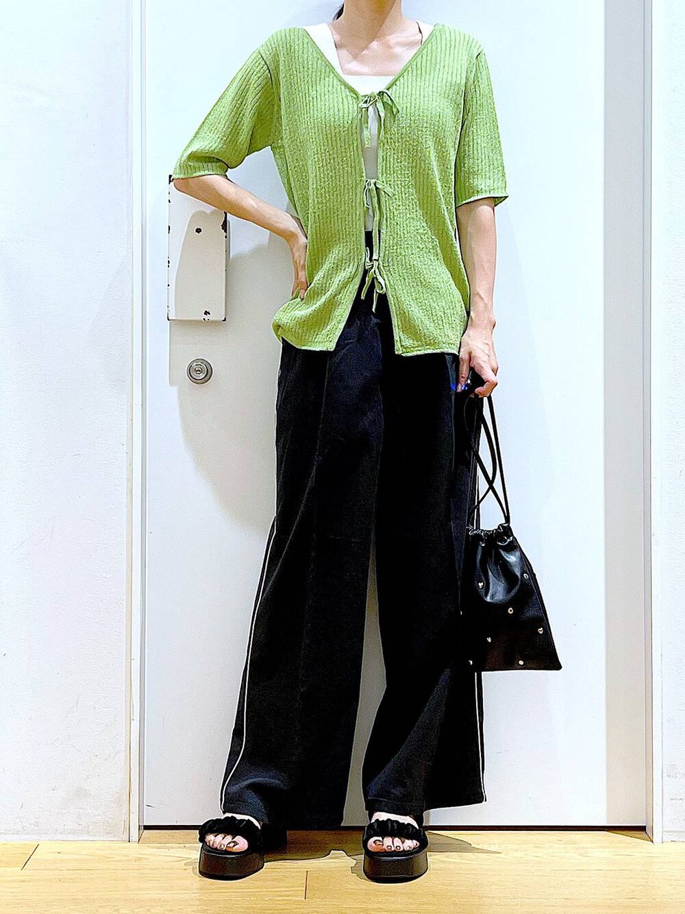 ブラック系のサンダル、ホワイト系のニット/セーター、ブラック系のショルダーバッグを着用したレディースの夏コーディネートの6枚目の写真