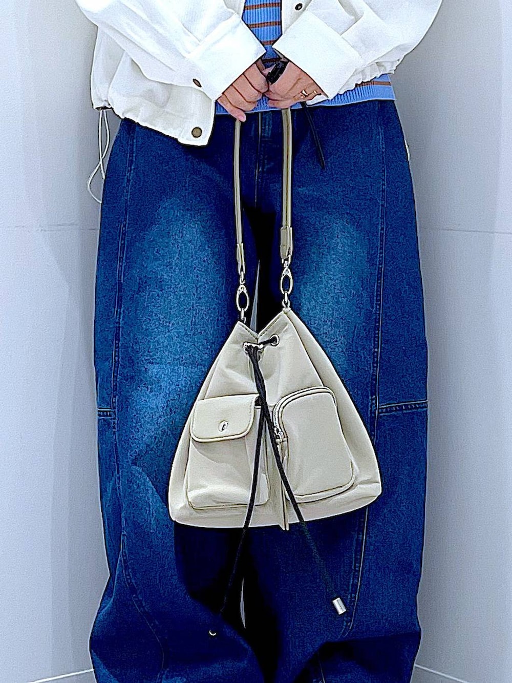 ブルー系のニット/セーター、ブルー系のデニムパンツ、ベージュ系のブルゾンを着用したレディースの冬コーディネートの9枚目の写真