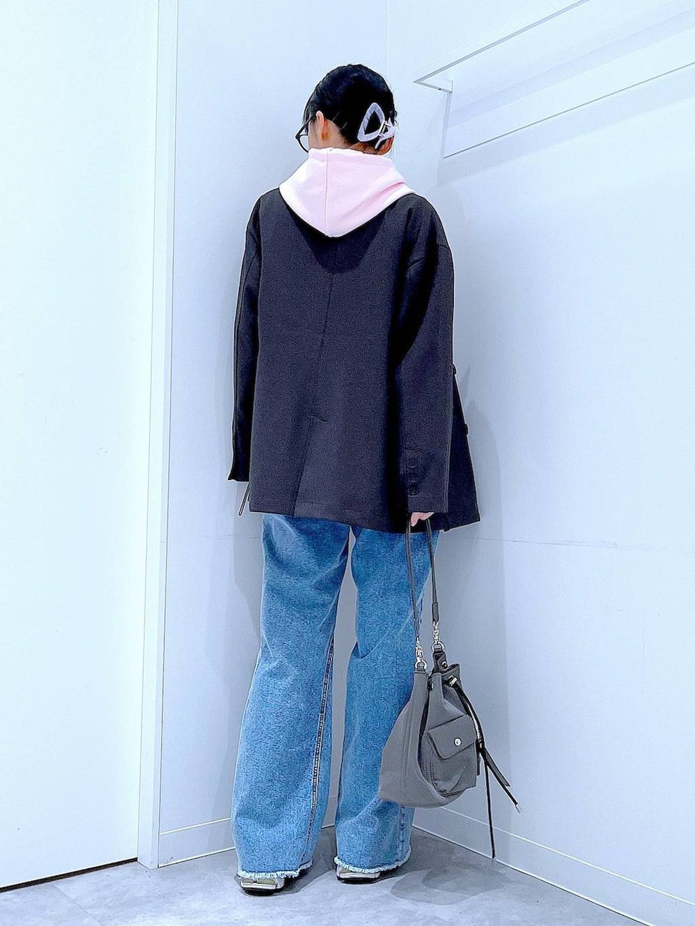 グレー系のテーラードジャケット、ブルー系のデニムパンツ、ピンク系のパーカーを着用したレディースの春コーディネートの5枚目の写真