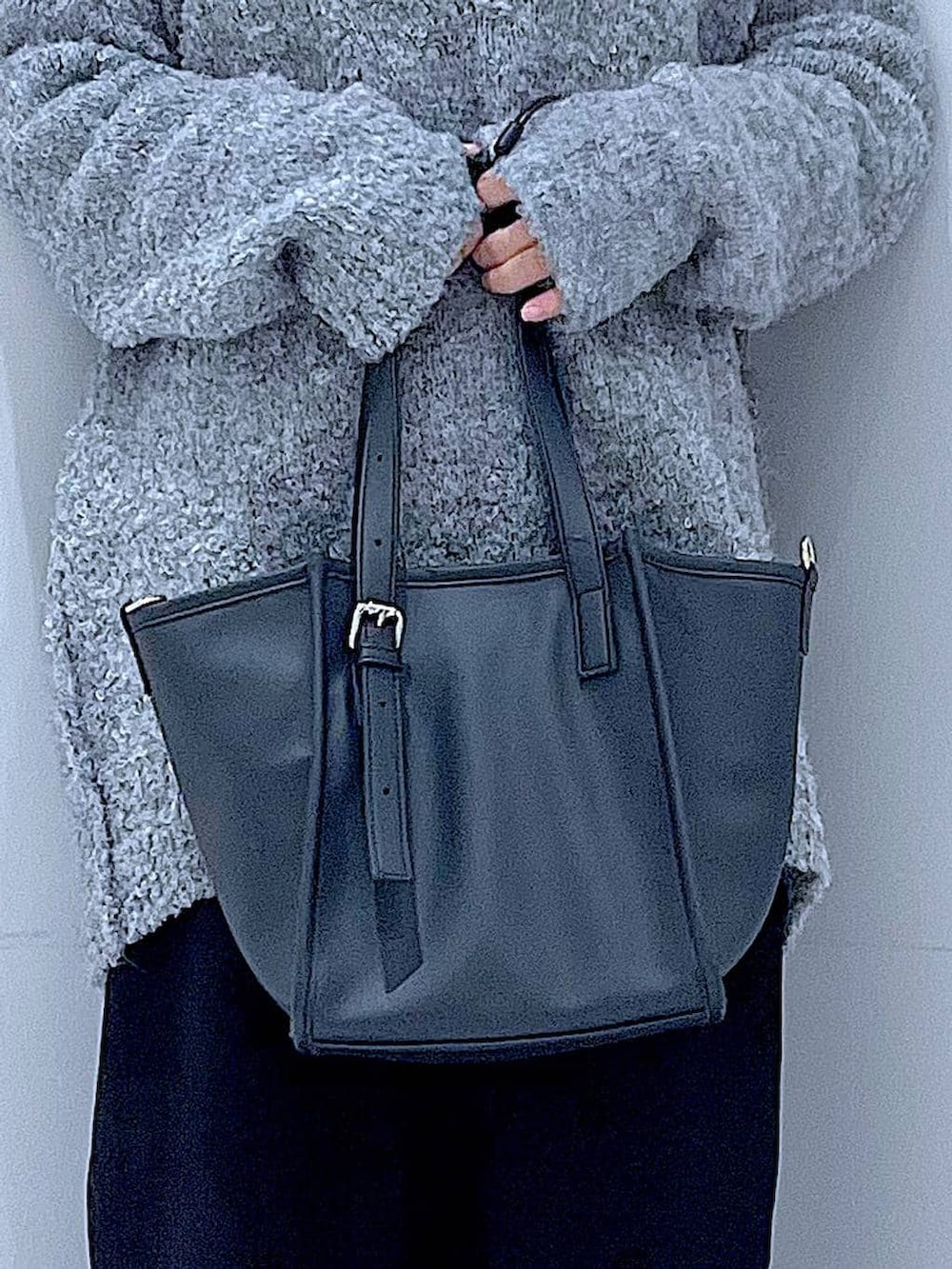 ブラック系のブーツ、グレー系のニット/セーター、ブラック系のスカートを着用したレディースの冬コーディネートの9枚目の写真