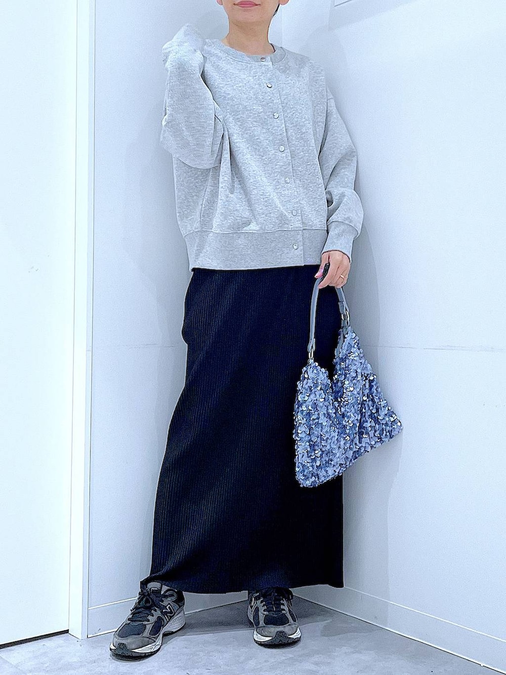 グレー系のカーディガン/ボレロ、ブルー系のショルダーバッグ、ブラック系のスカートを着用したレディースの春コーディネートの6枚目の写真