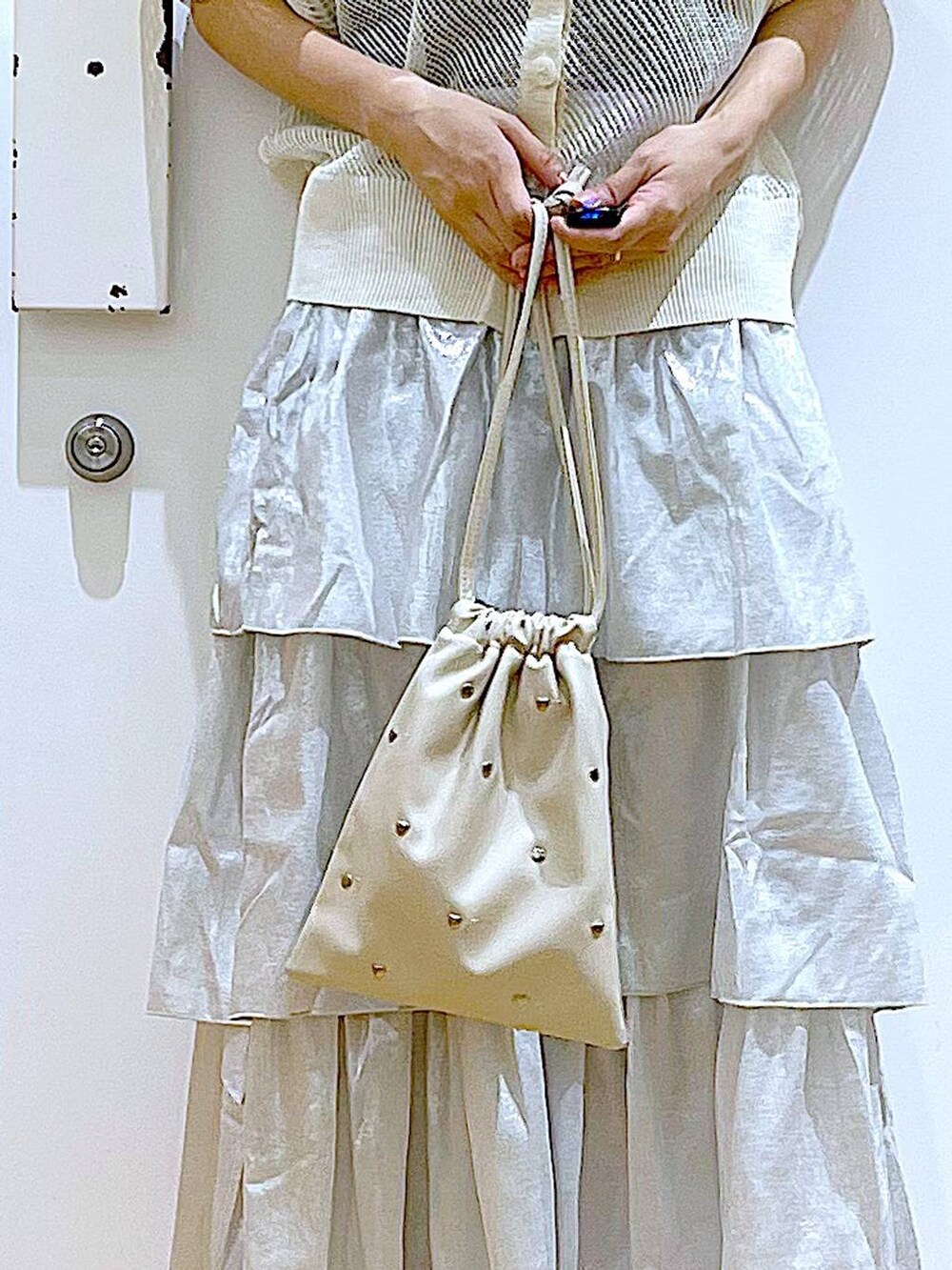 シルバー系のサンダル、ホワイト系のショルダーバッグ、シルバー系のスカートを着用したレディースの夏コーディネートの9枚目の写真