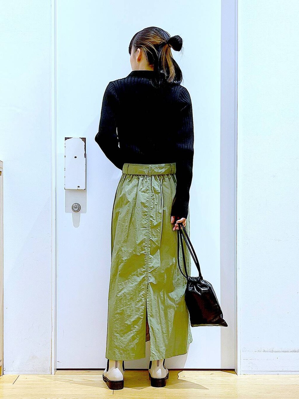 ブラック系のカーディガン/ボレロ、ベージュ系のブーツ、ブラック系のショルダーバッグを着用したレディースの春コーディネートの5枚目の写真