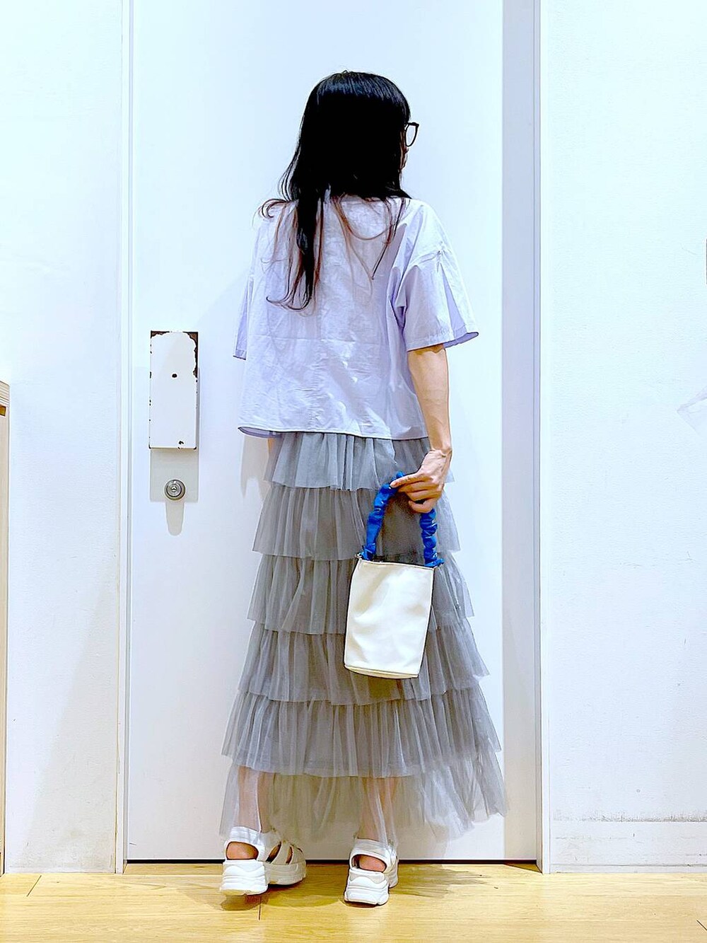 ブルー系のショルダーバッグ、ホワイト系のサンダル、グレー系のスカートを着用したレディースの夏コーディネートの5枚目の写真