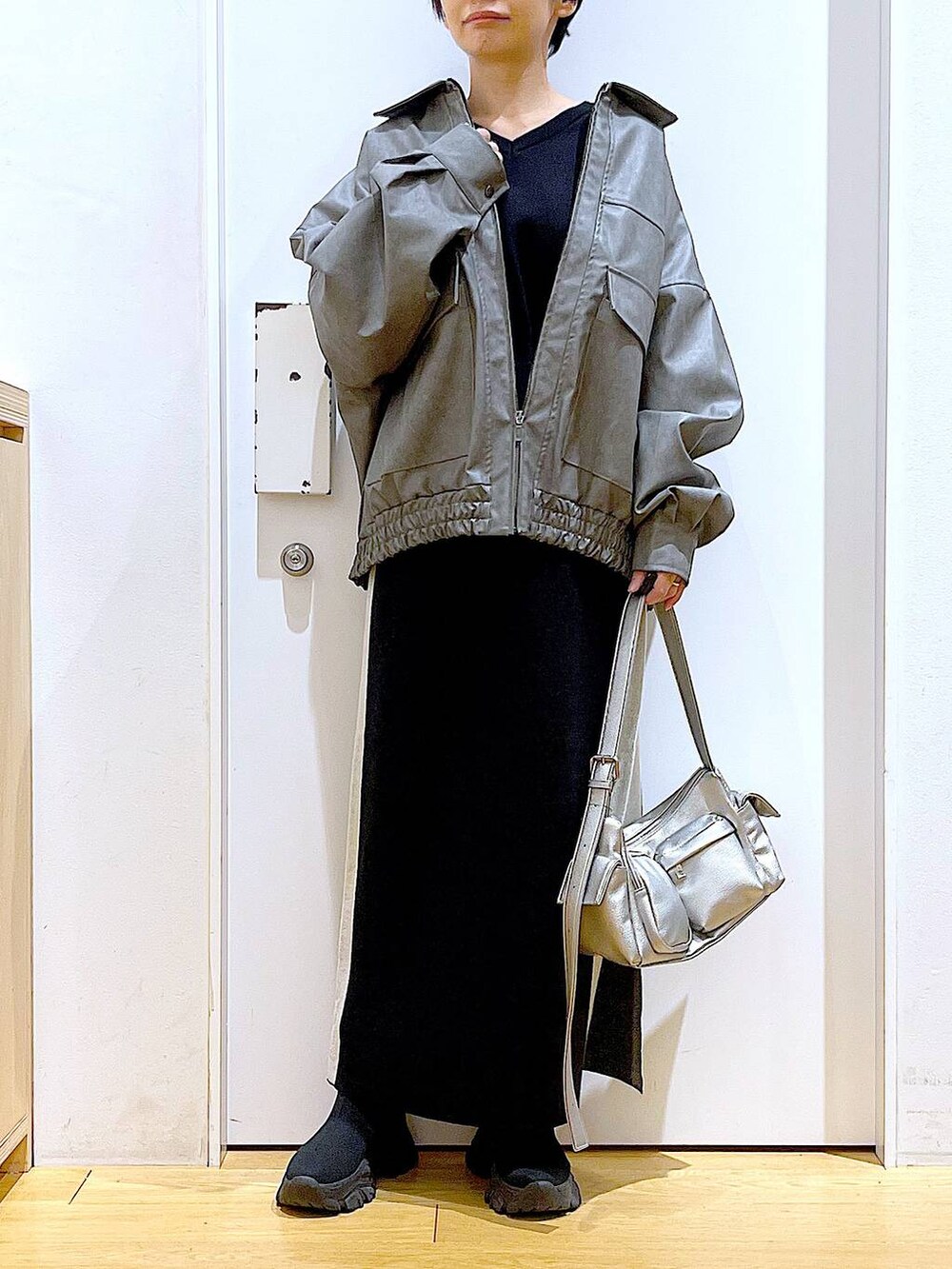 ブラック系のスカート、グレー系のブルゾン、ブラック系のブーツを着用したレディースの冬コーディネートの6枚目の写真