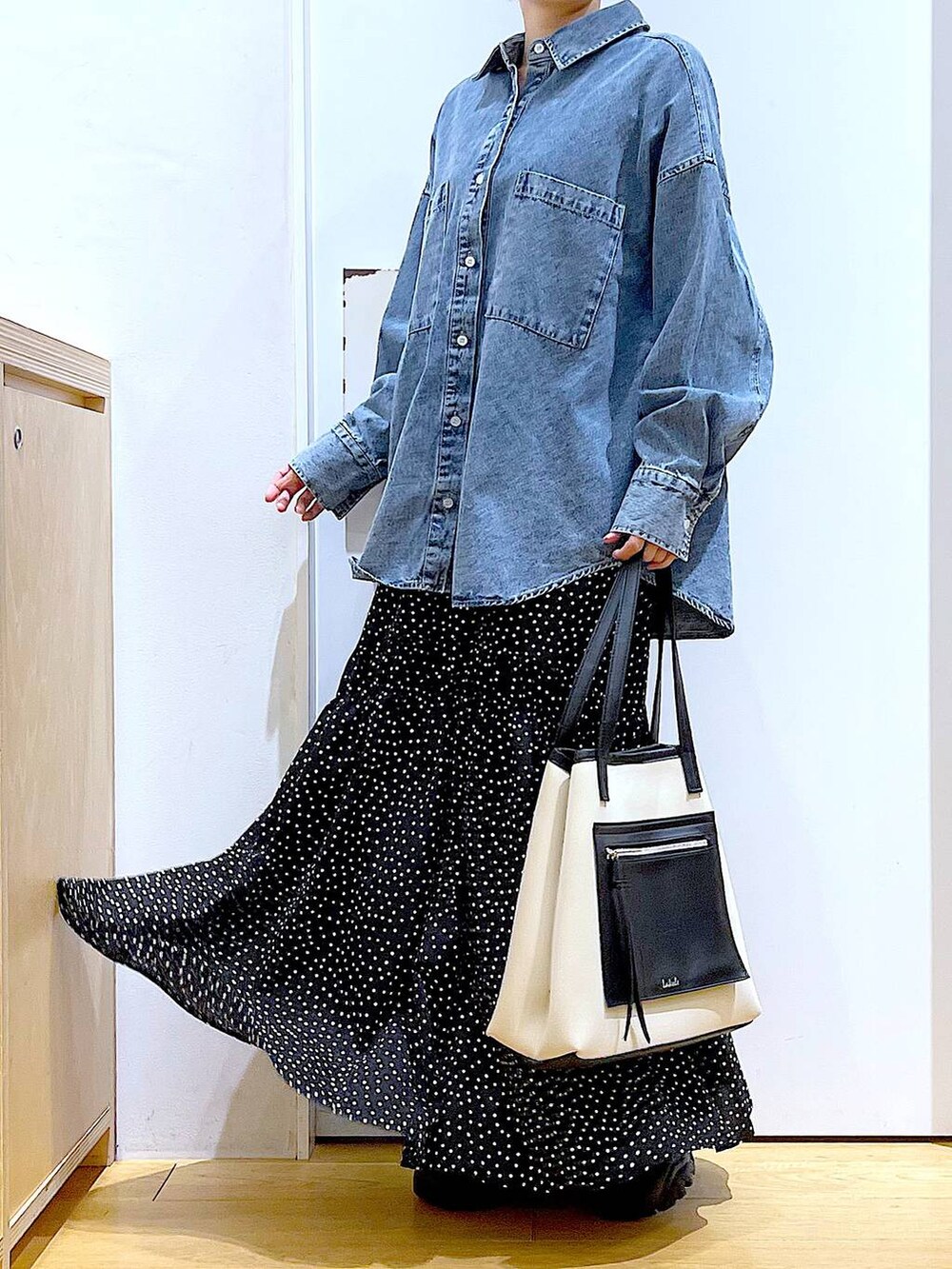 ブラック系のブーツ、ブルー系のシャツ/ブラウス、ホワイト系のトートバッグを着用したレディースの春コーディネートの6枚目の写真