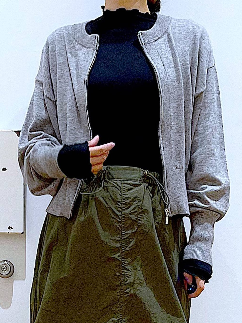 ブラック系のTシャツ/カットソー、グレー系のカーディガン/ボレロ、ブラック系のブーツを着用したレディースの冬コーディネートの7枚目の写真