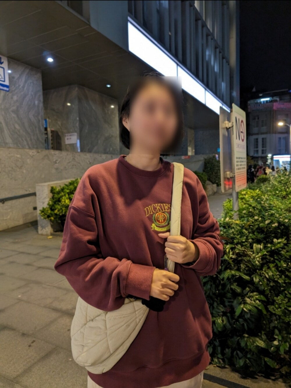 ピンク系のスウェット、ベージュ系のチノパンツ、ベージュ系のショルダーバッグを着用したレディースの冬コーディネートの2枚目の写真