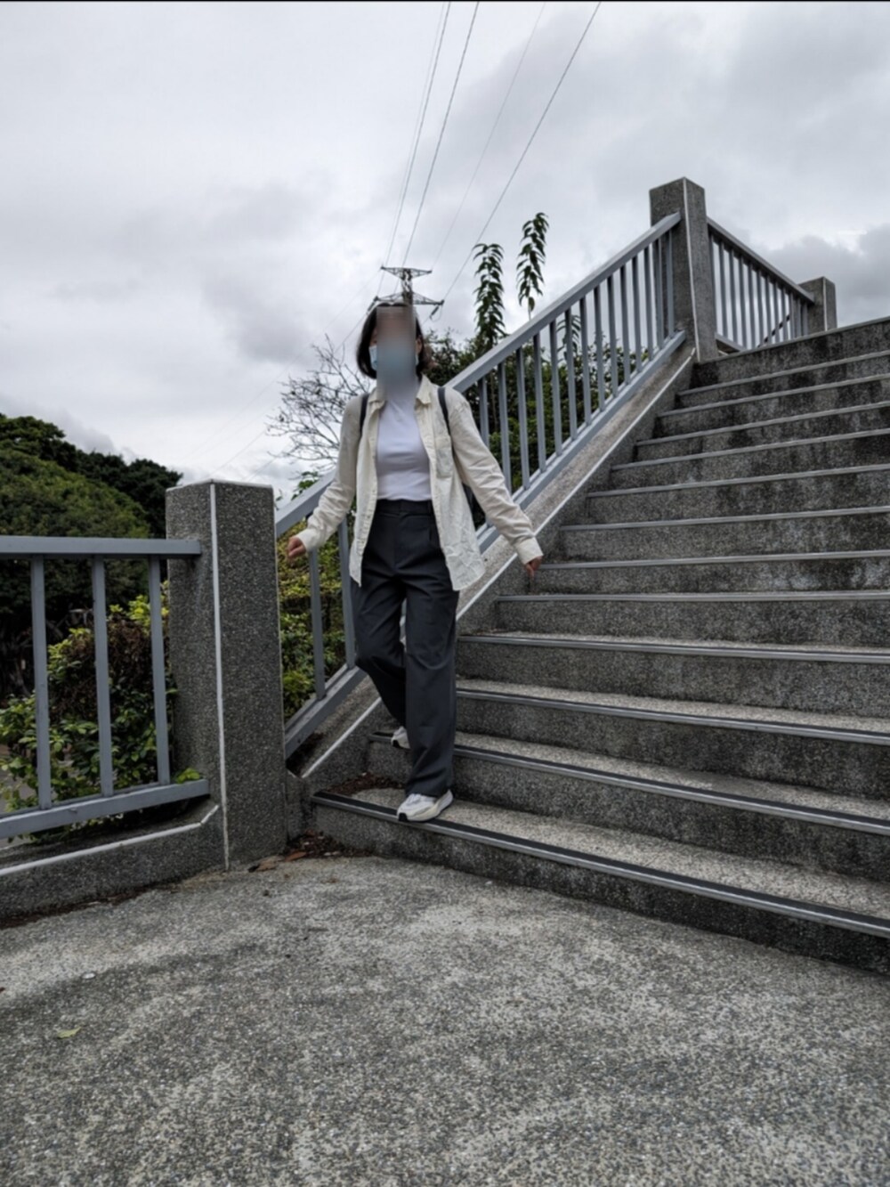 グレー系のチノパンツ、ホワイト系のニット/セーター、ホワイト系のシャツ/ブラウスを着用したレディースの冬コーディネートの2枚目の写真