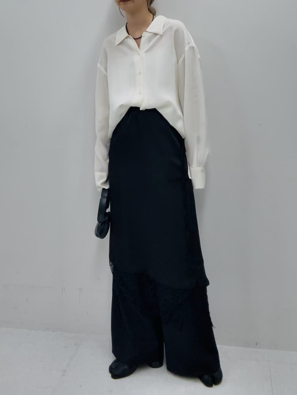 ホワイト系のシャツ/ブラウス、ブラック系のスカート、ブラック系のスラックスを着用したレディースの冬コーディネートの3枚目の写真