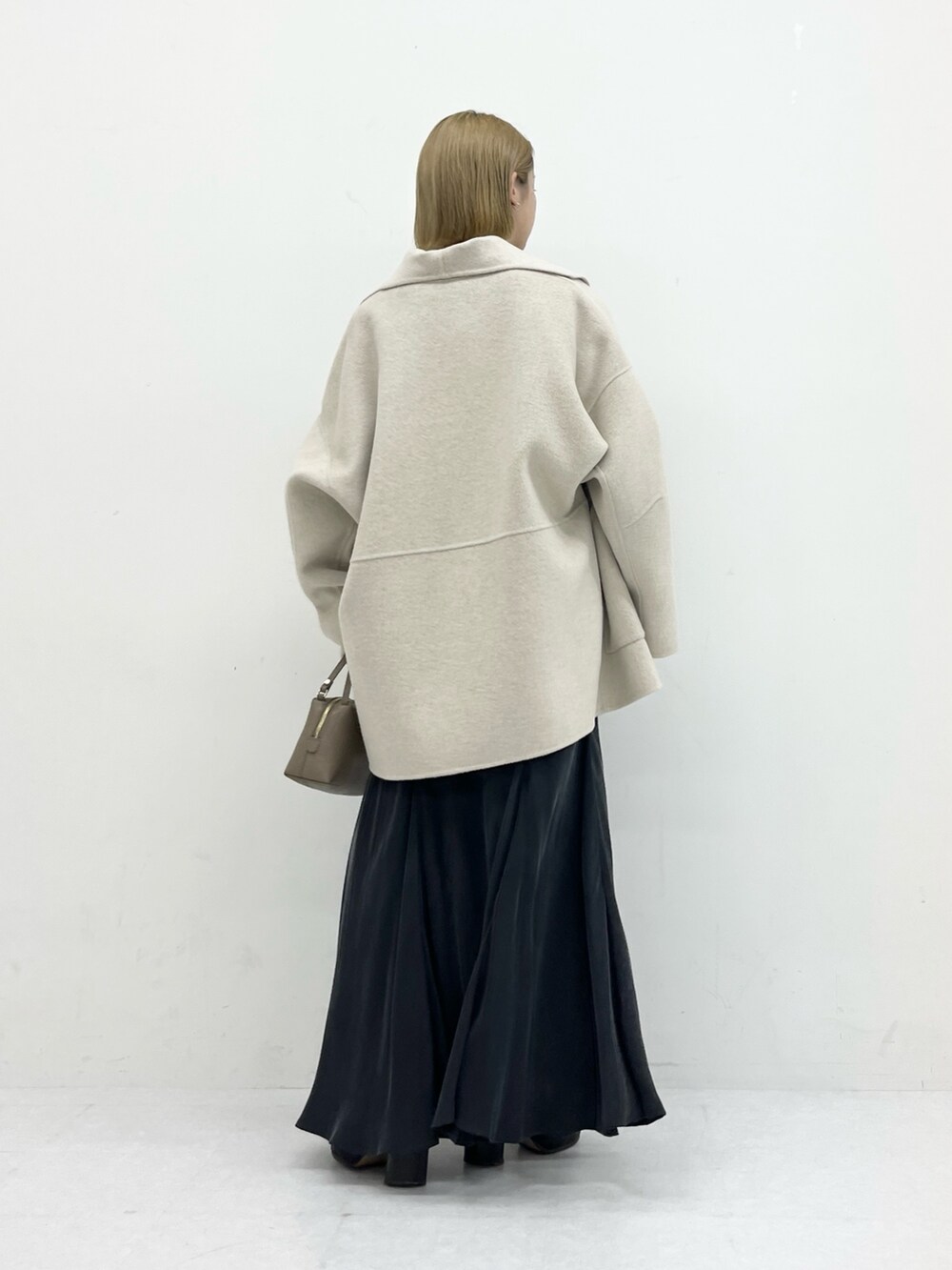 ベージュ系のその他アウター、グレー系のスカート、ブルー系のニット/セーターを着用したレディースの冬コーディネートの3枚目の写真