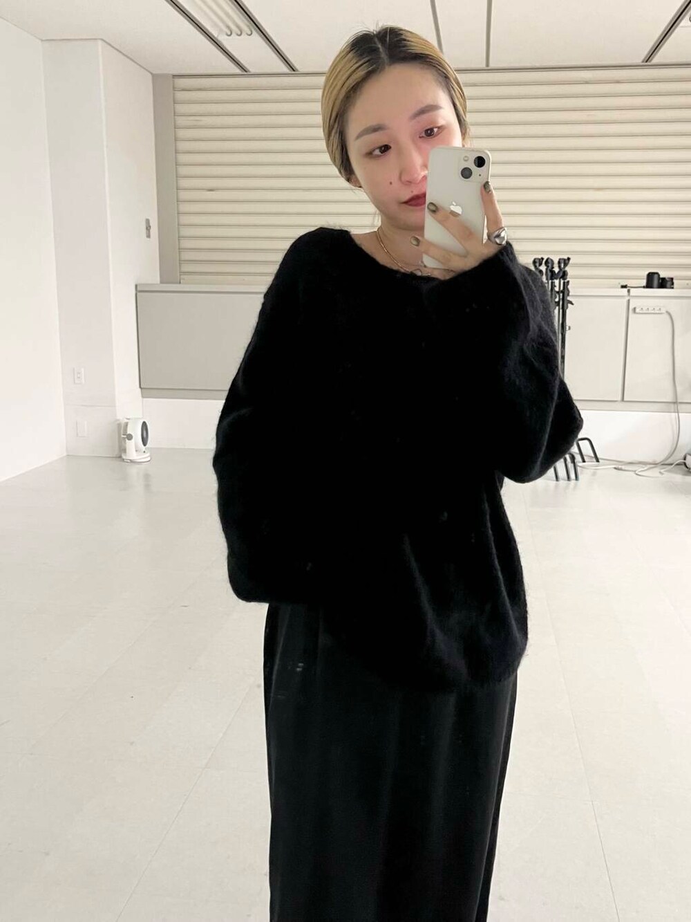 グリーン系のチェスターコート、ブラック系のトートバッグ、ブラック系のニット/セーターを着用したレディースの冬コーディネートの3枚目の写真