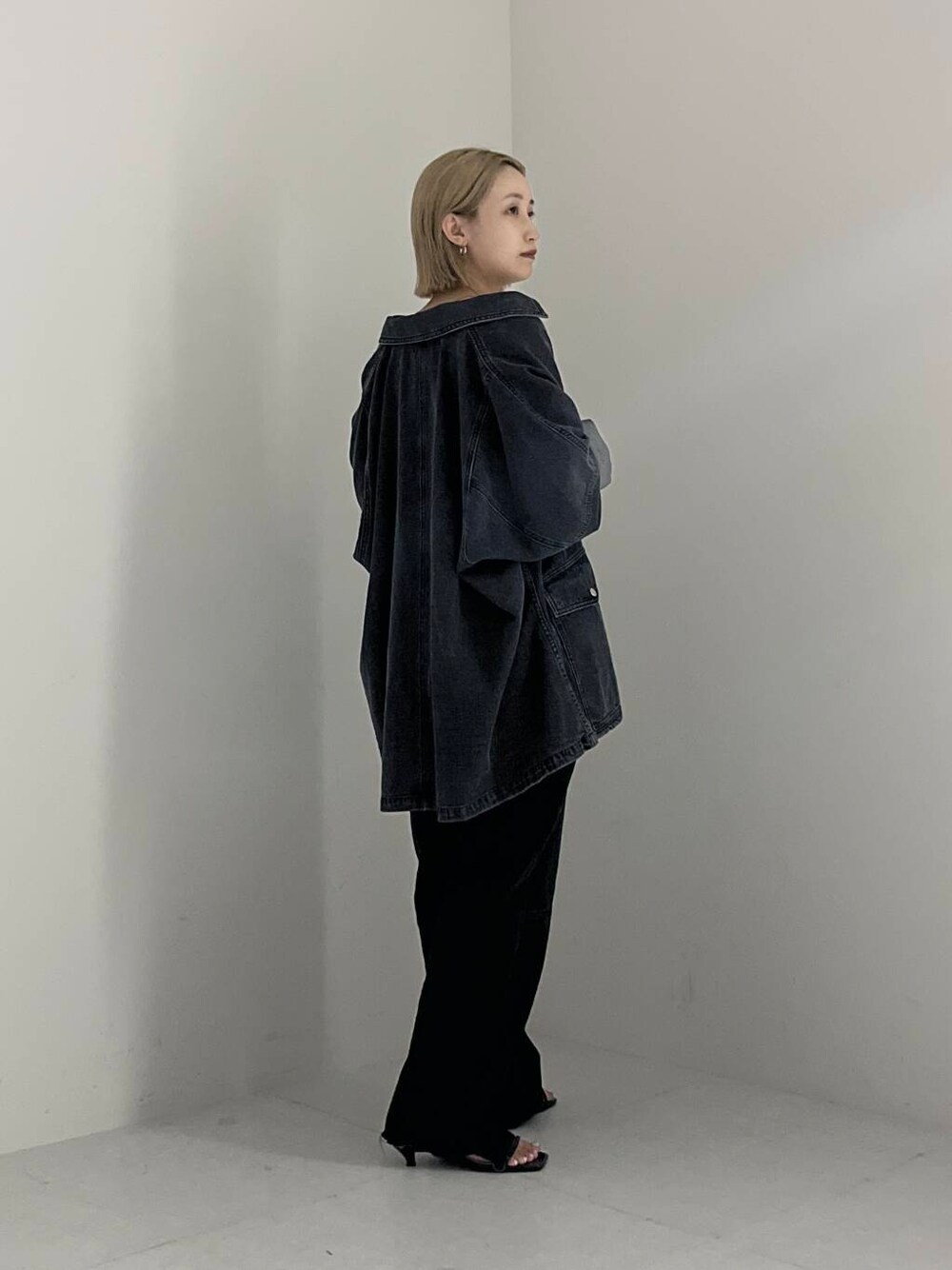 ブラック系のサンダル、グレー系のデニムジャケット、ブラック系のデニムパンツを着用したレディースの夏コーディネートの2枚目の写真