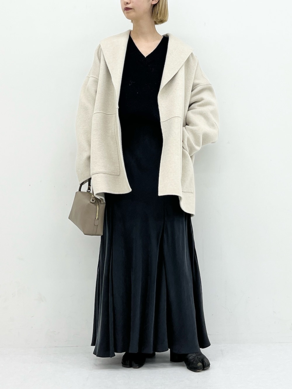 ベージュ系のその他アウター、グレー系のスカート、ブルー系のニット/セーターを着用したレディースの冬コーディネートの4枚目の写真