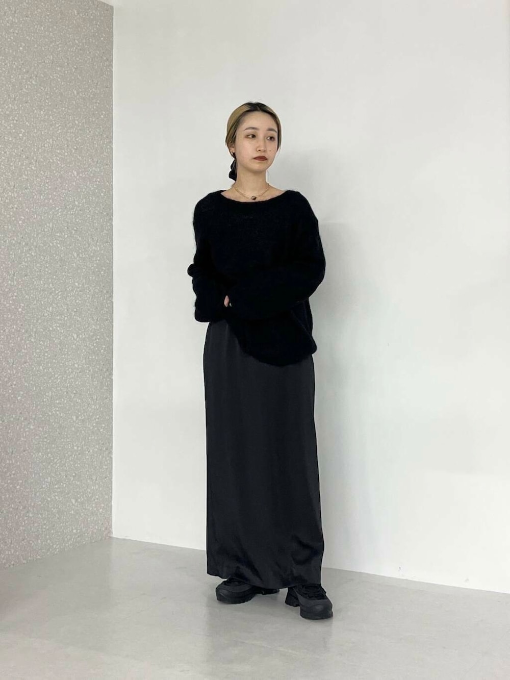 グリーン系のチェスターコート、ブラック系のトートバッグ、ブラック系のニット/セーターを着用したレディースの冬コーディネートの2枚目の写真