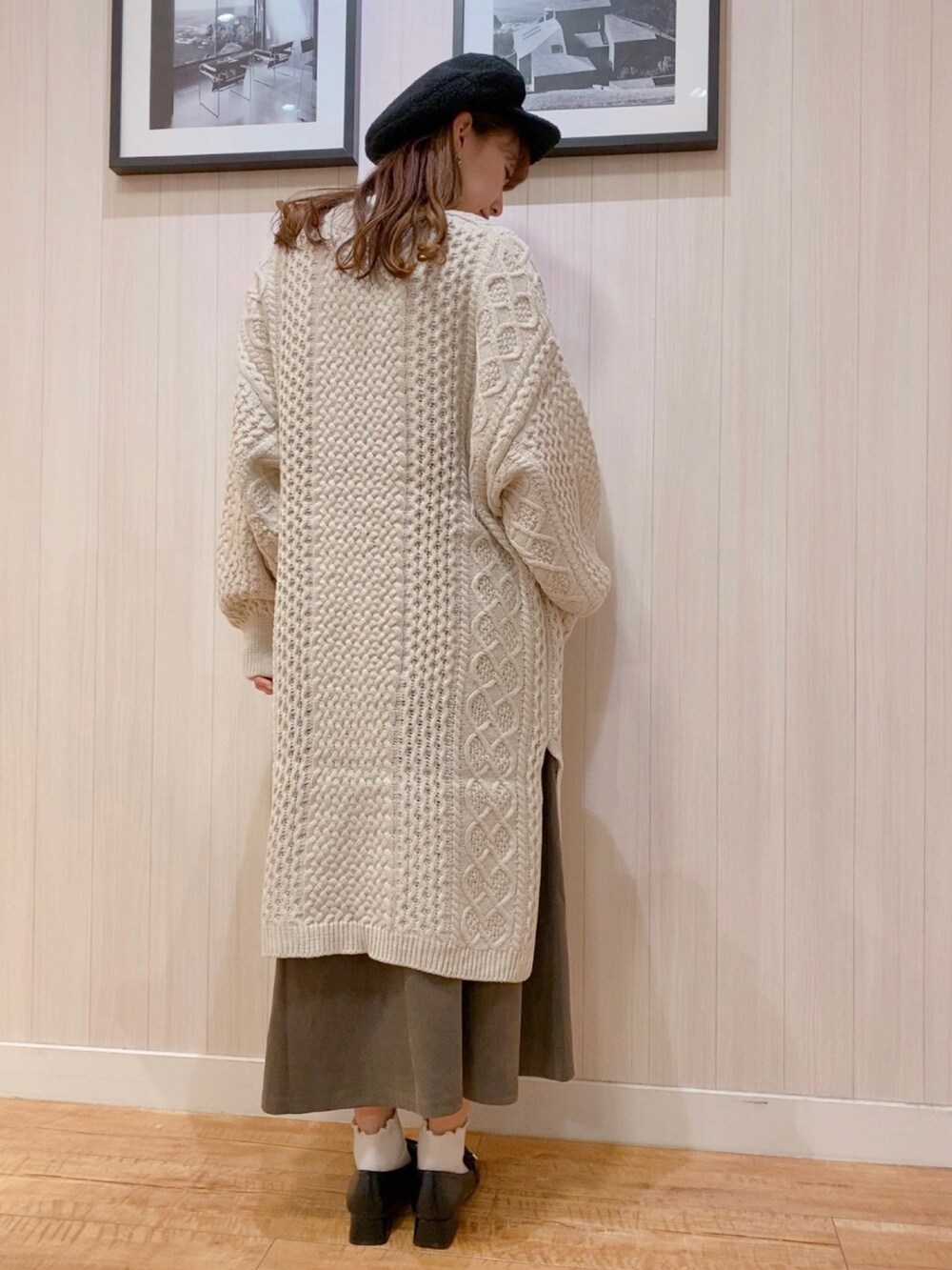 ホワイト系のカーディガン/ボレロ、ホワイト系のニット/セーター、ブラウン系のスカートを着用したレディースの秋コーディネートの2枚目の写真