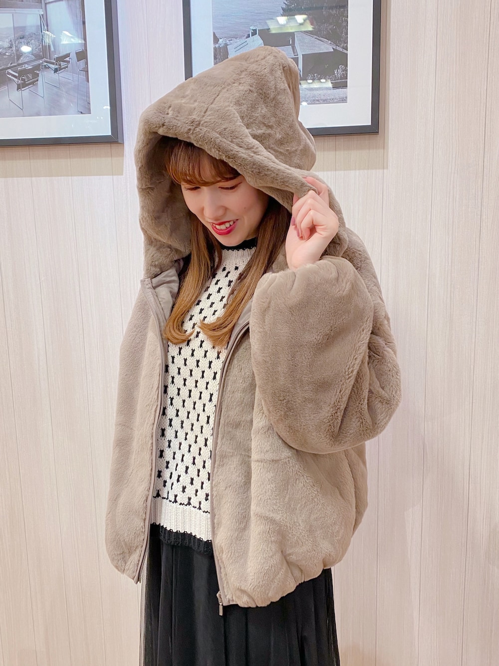 ベージュ系のニット/セーター、ベージュ系のスニーカー、ブラック系のスカートを着用したレディースの冬コーディネートの2枚目の写真