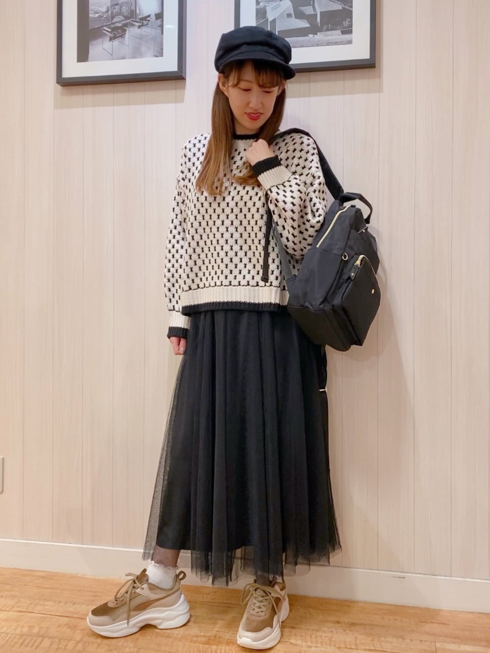 ベージュ系のニット/セーター、ベージュ系のスニーカー、ブラック系のスカートを着用したレディースの冬コーディネートの5枚目の写真