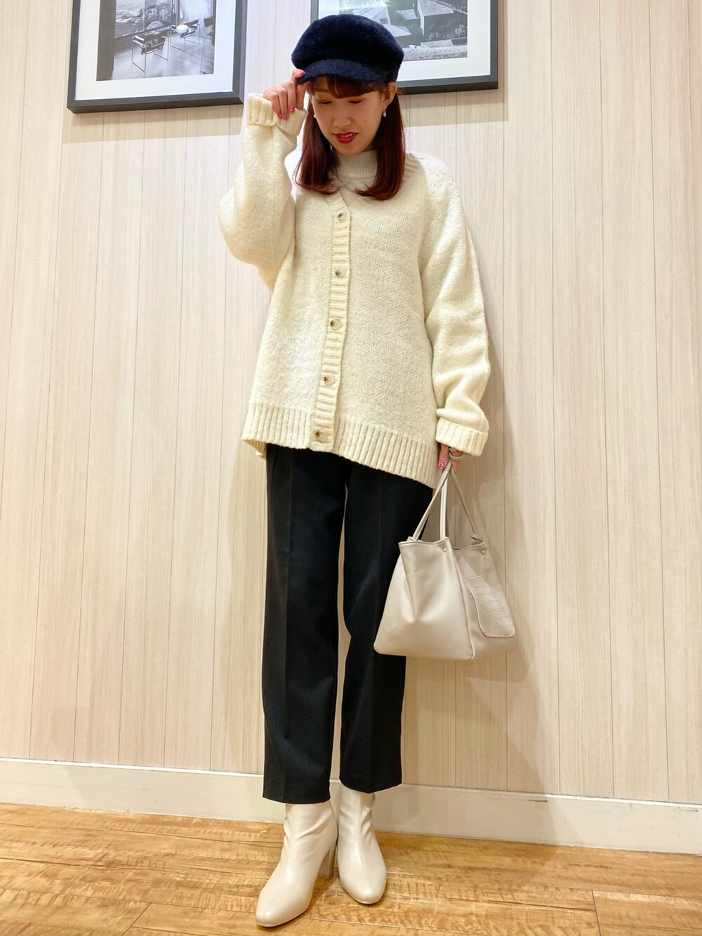 ピンク系のニット/セーター、ホワイト系のカーディガン/ボレロ、グレー系のトートバッグを着用したレディースの春コーディネートの2枚目の写真