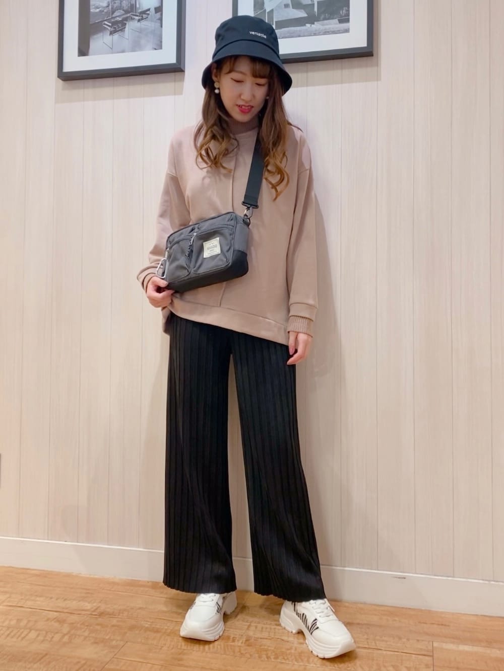 ピンク系のスウェット、ホワイト系のブルゾン、グレー系のショルダーバッグを着用したレディースの秋コーディネートの2枚目の写真