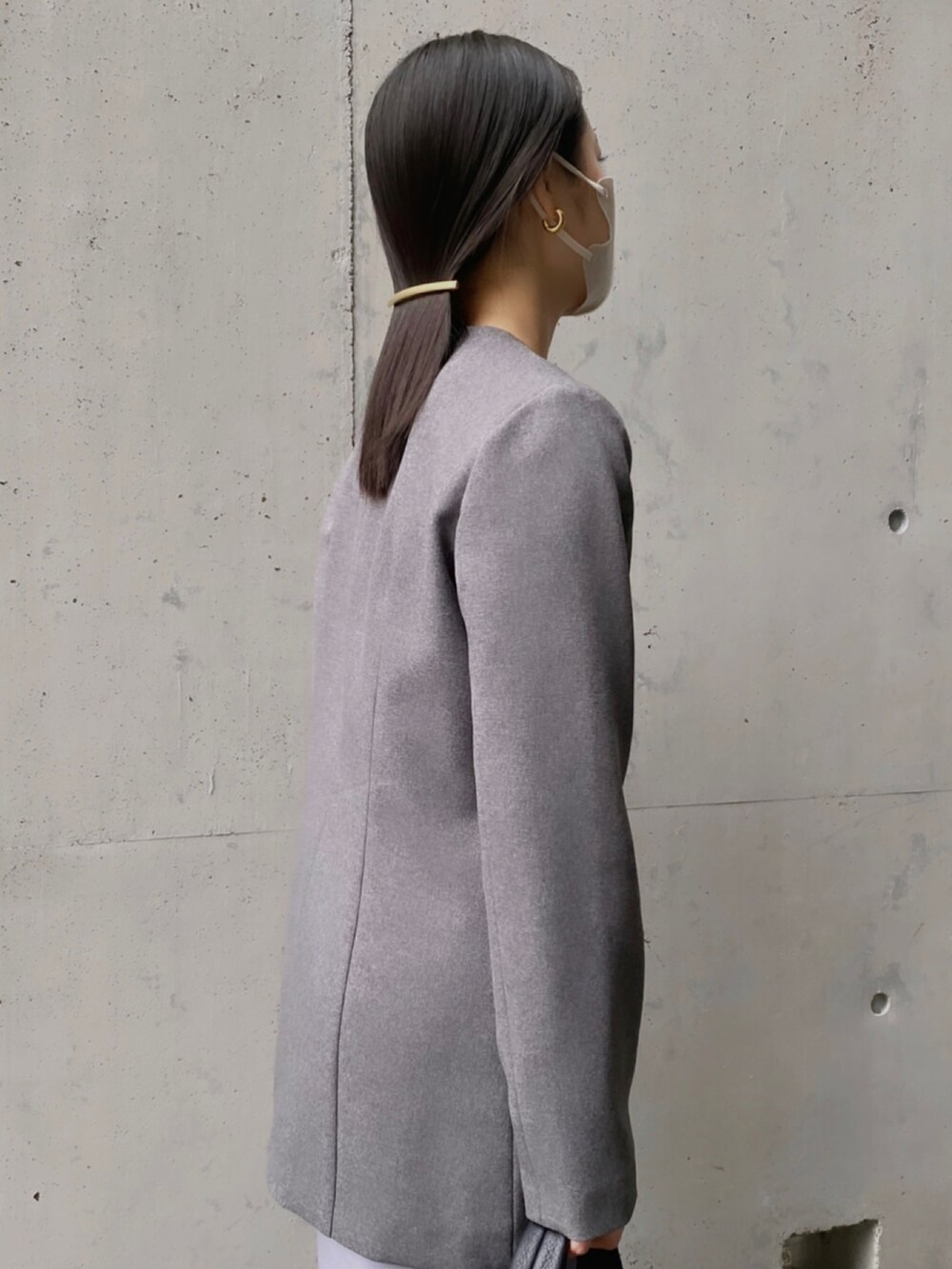 グレー系のジャケット/アウター、ブラック系のハンドバッグ、パープル系のスカートを着用したレディースの春コーディネートの2枚目の写真