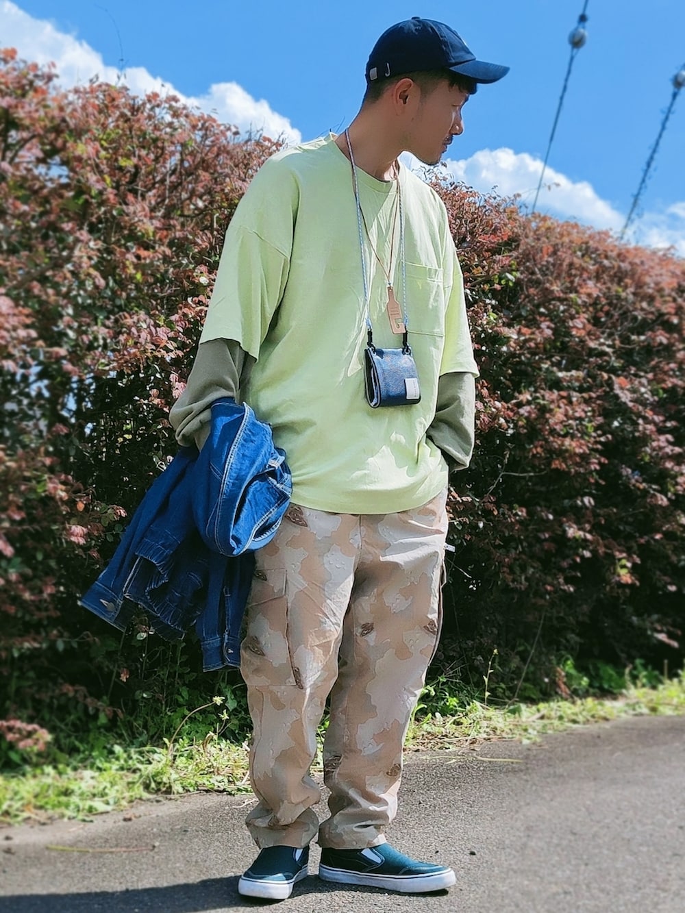 グリーン系のスニーカー、ベージュ系のカーゴパンツ、ブルー系のデニムジャケットを着用したメンズの春コーディネートの2枚目の写真