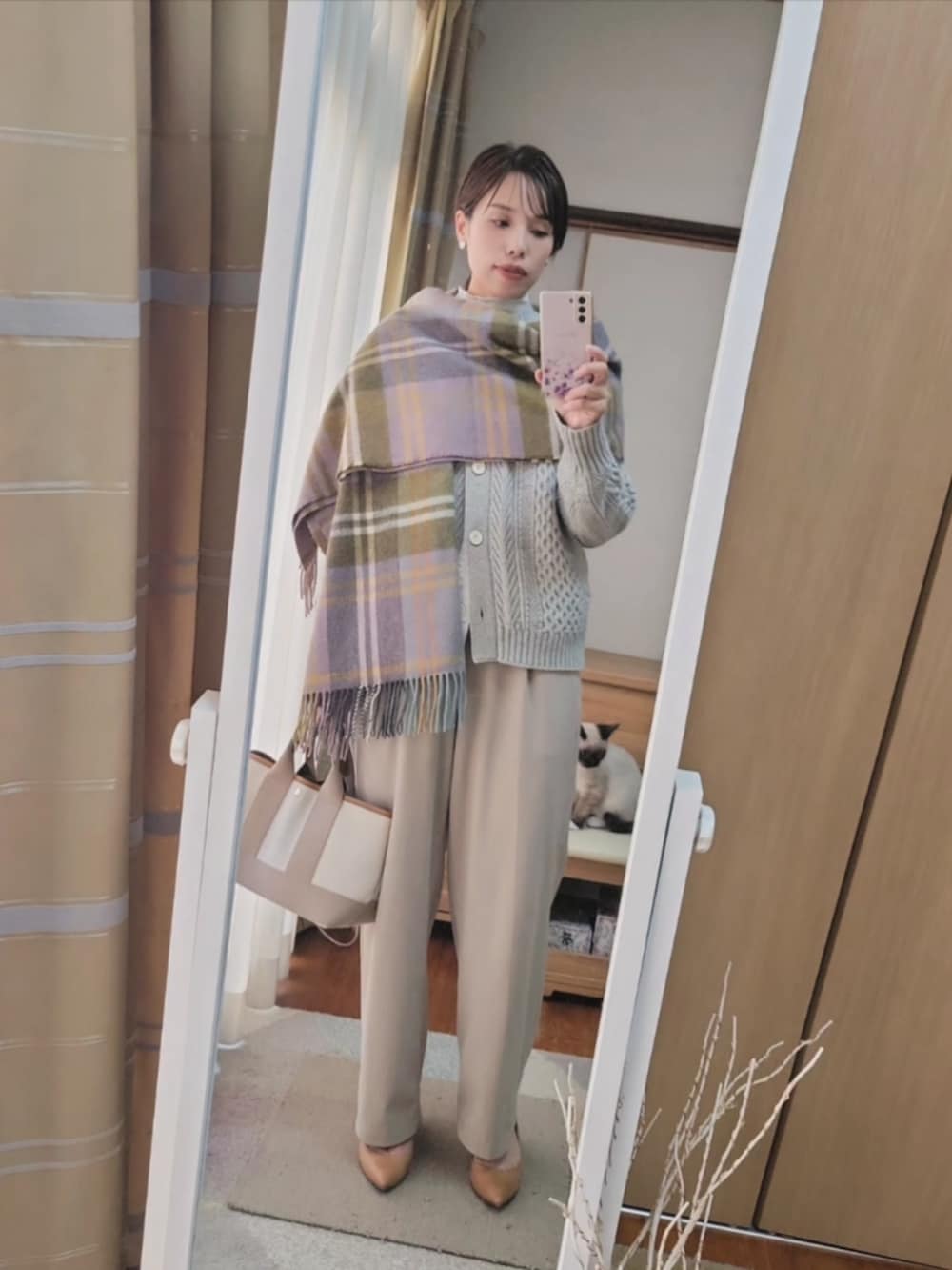 ベージュ系のトートバッグ、グレー系のカーディガン/ボレロ、パープル系のストール/ショールを着用したレディースの冬コーディネートの2枚目の写真